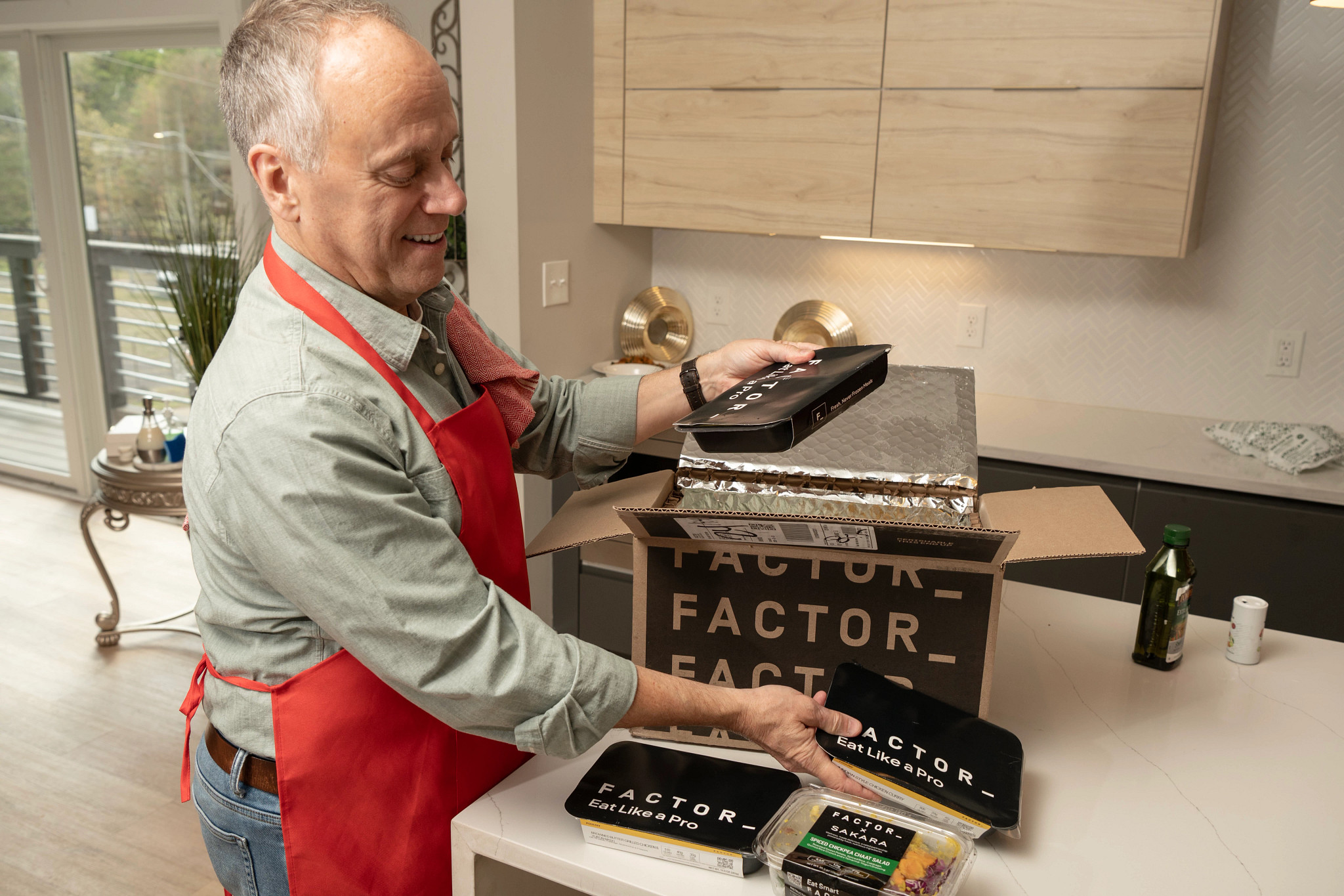  An older adult tester unpacking a Factor meal delivery box.