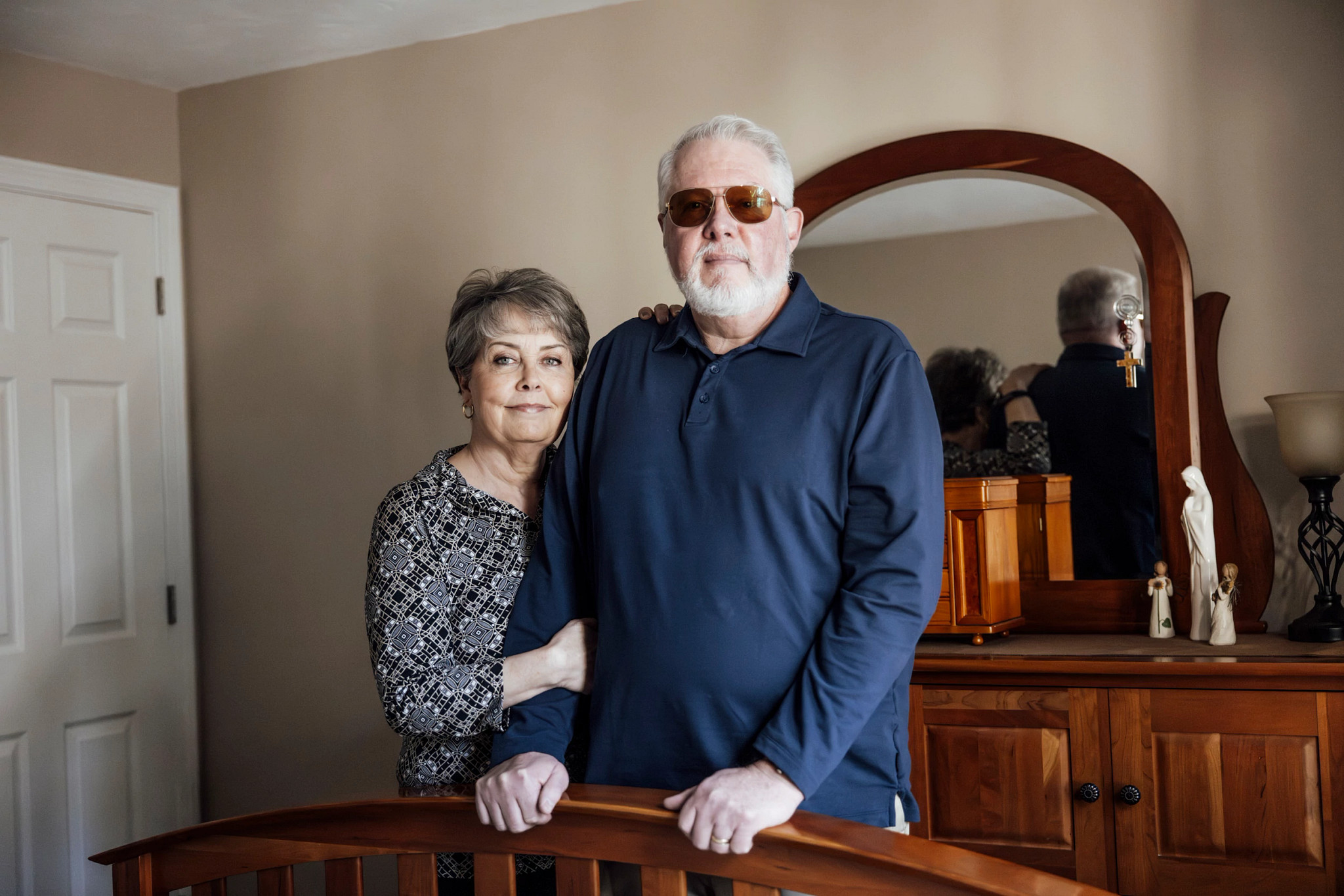 two people standing in a bedroom