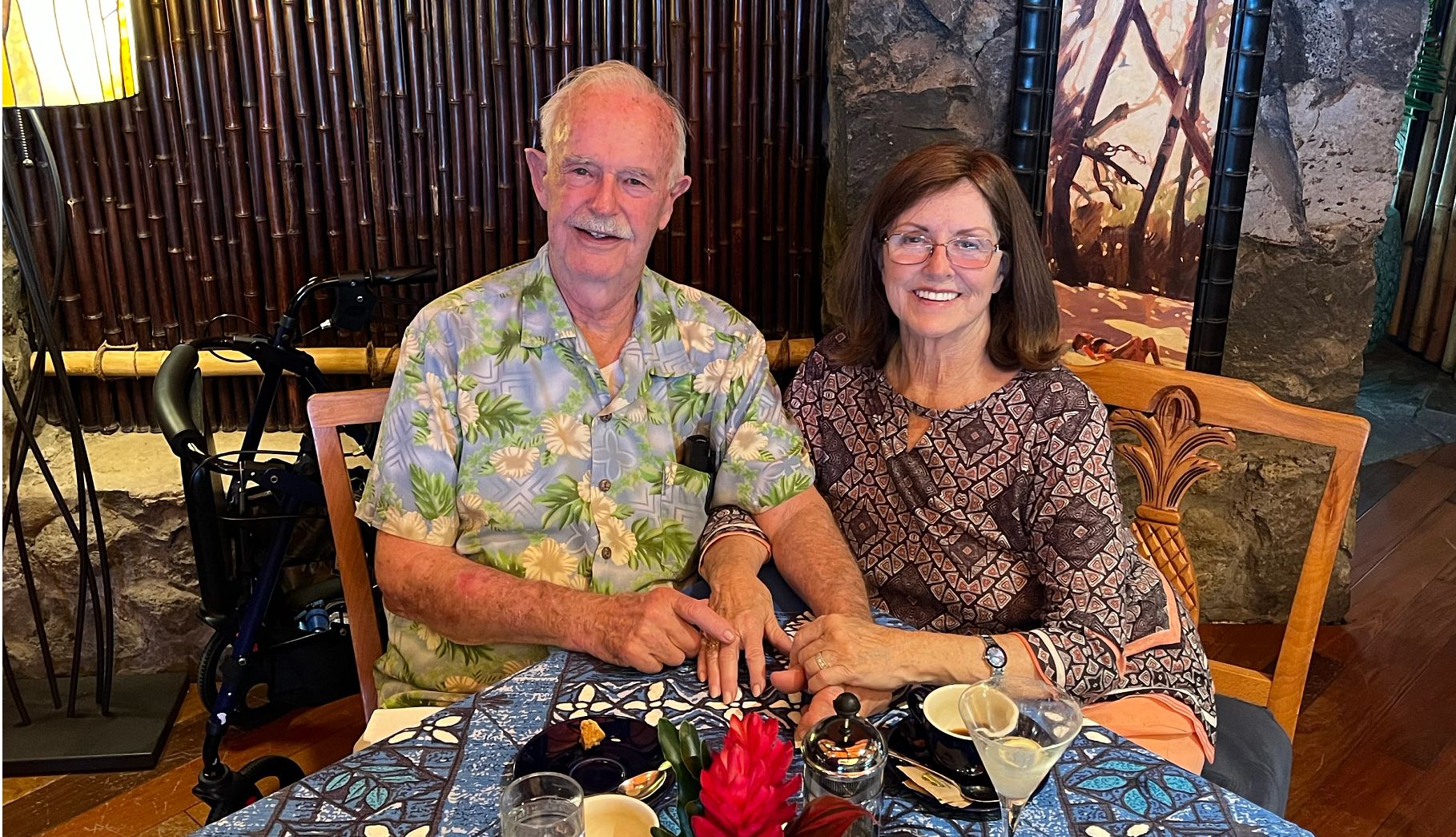 Couples smiling faces and a shared meal. Bob and Barbara in Hawaii enjoying a special meal in a tropical setting.