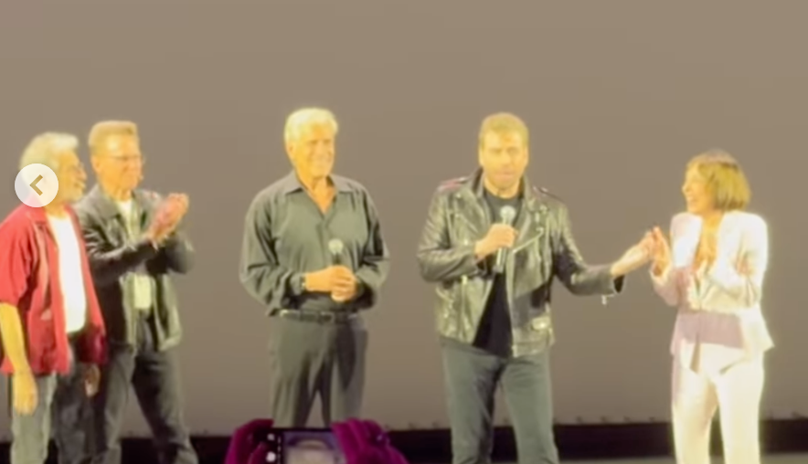 John Travolta Transforms Into Danny Zuko john travolta on stage with other 'grease' cast members