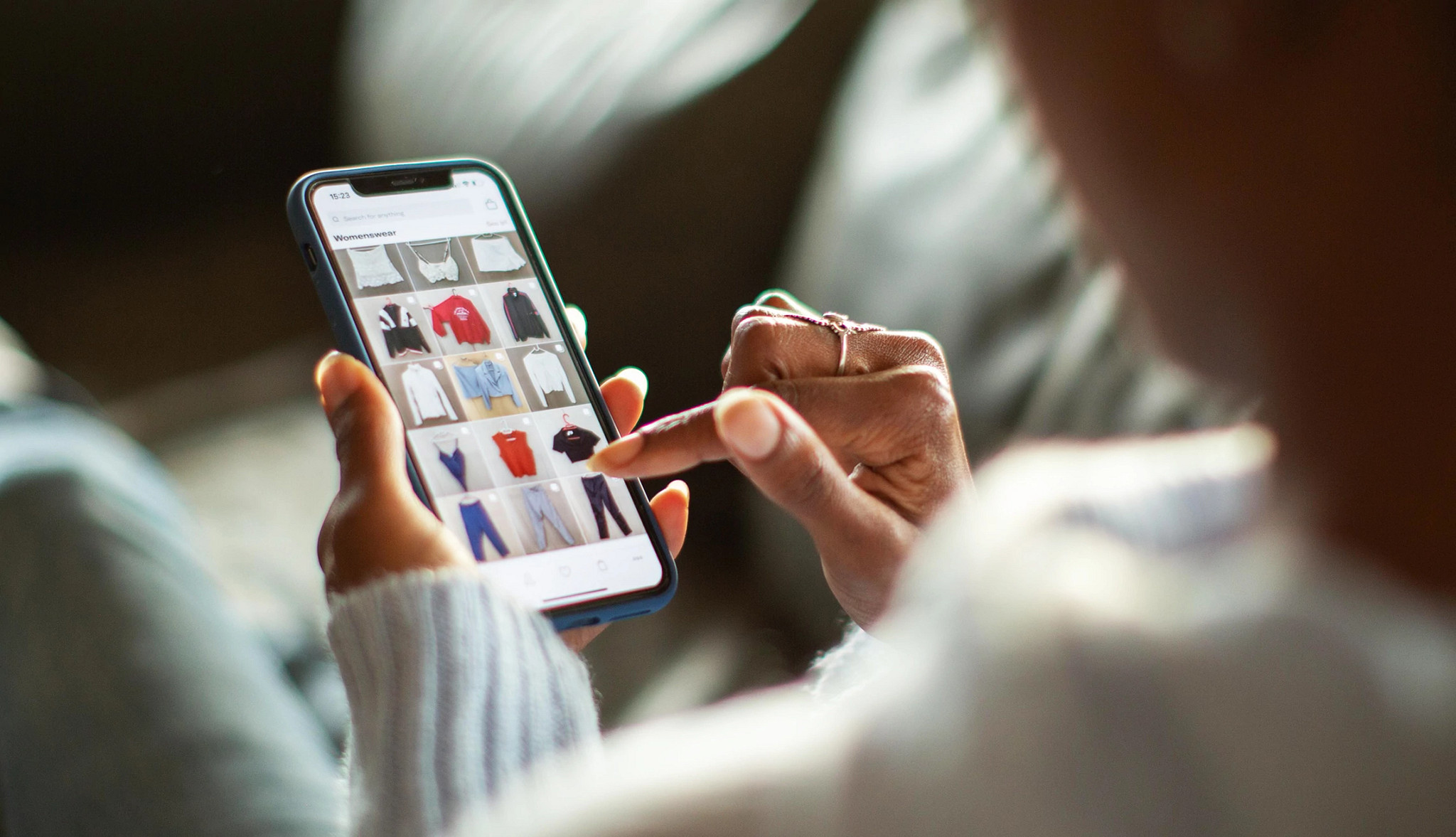 a person using a smartphone to shop for clothing