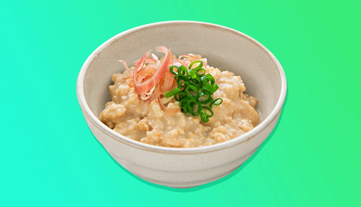 Savory oatmeal garnished with scallions and ginger in a small bowl.