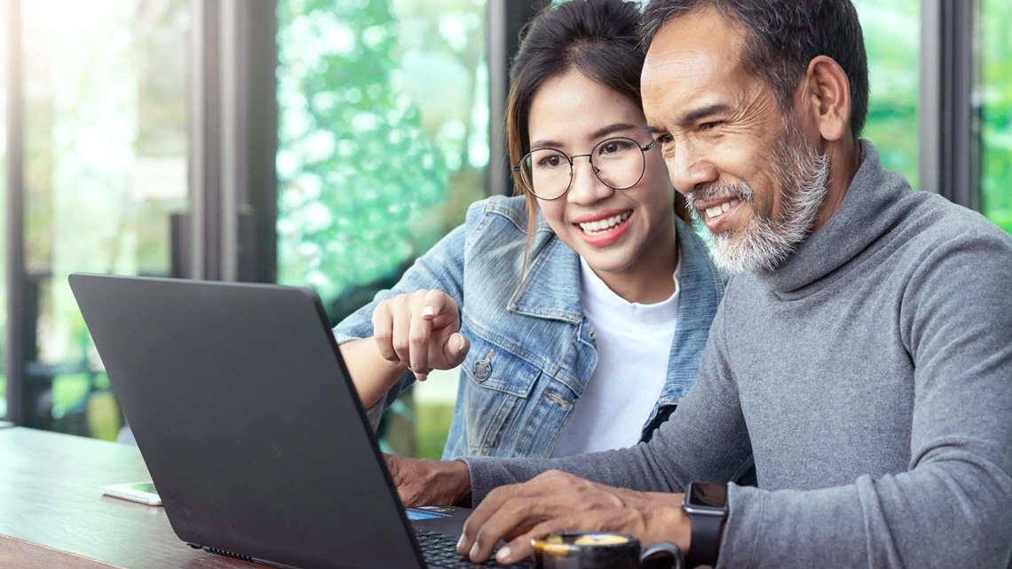 a man and woman at home looking at a laptop together