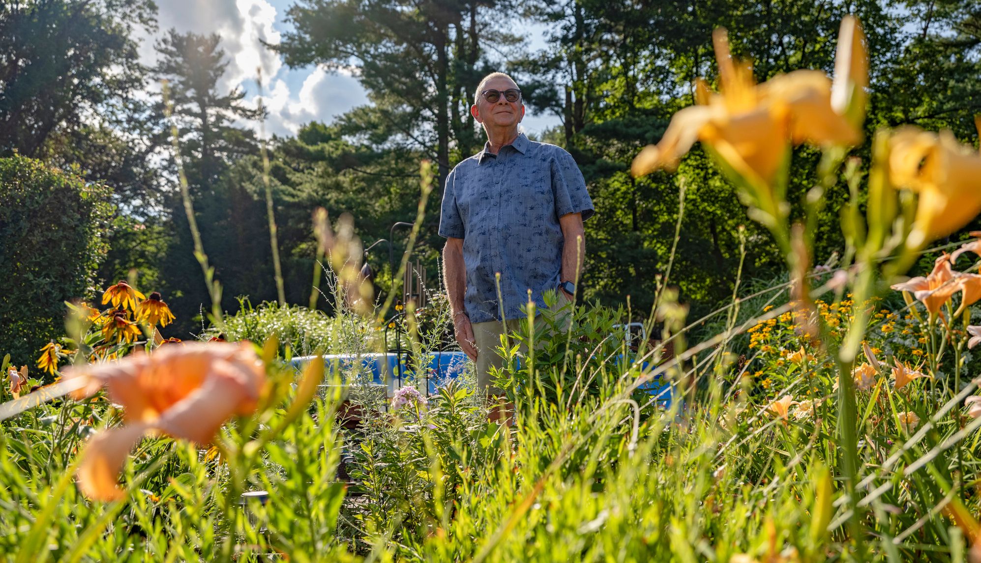 I Volunteered Too Much in Retirement a man stands in a garden, looking into the distance