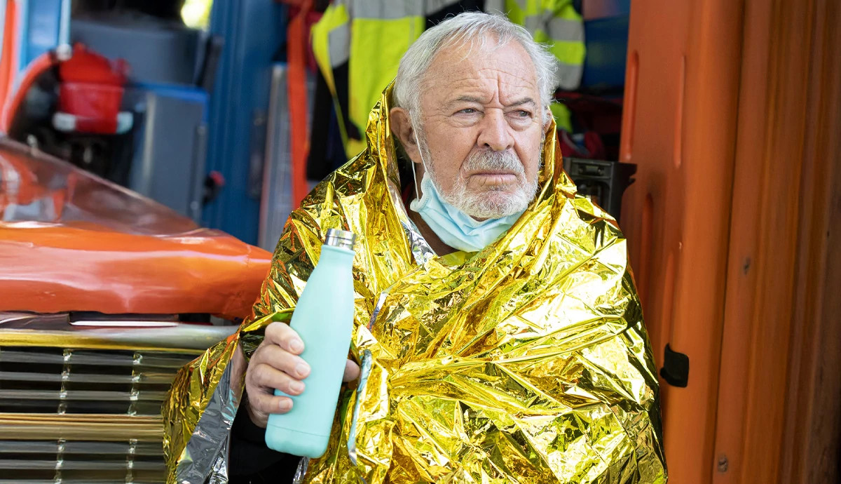 man wrapped in emergency blanket