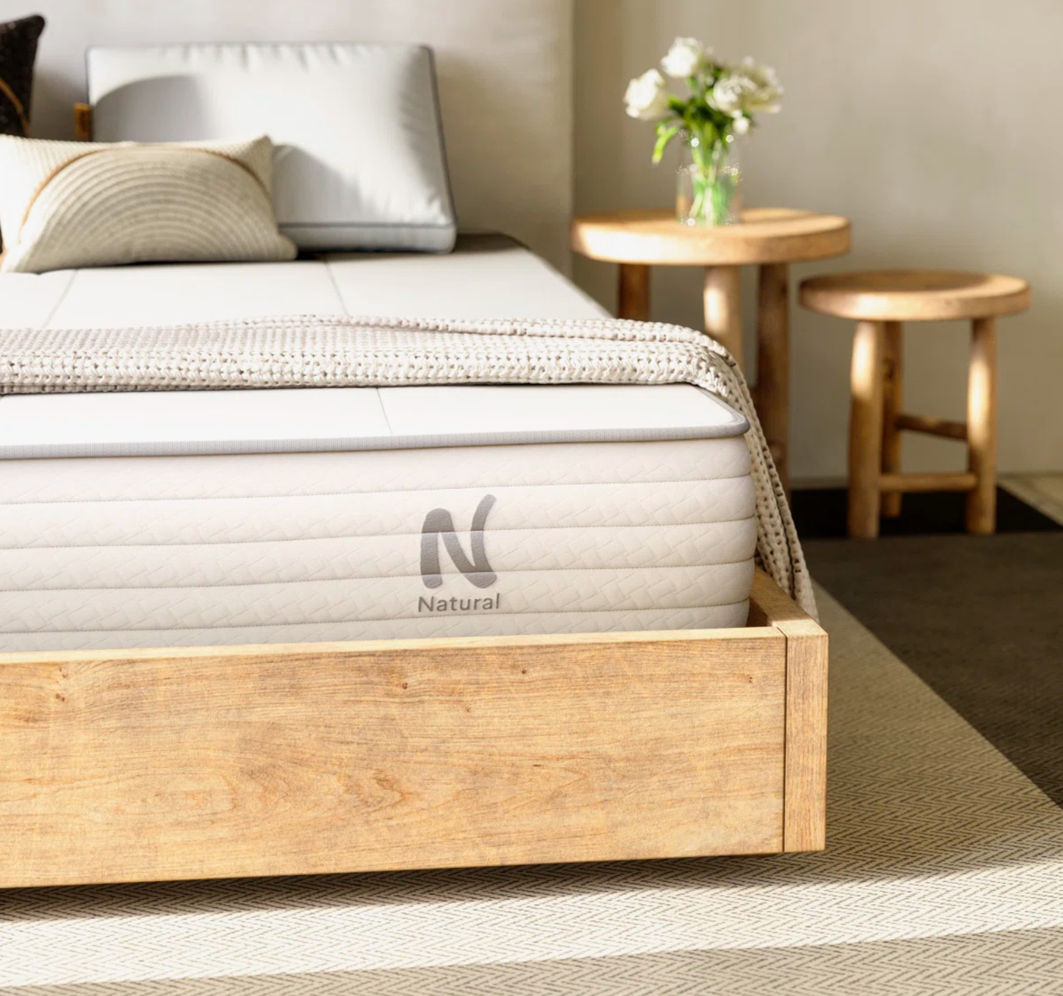 The Nolah Natural mattress displayed on a wooden bedframe in a bedroom 