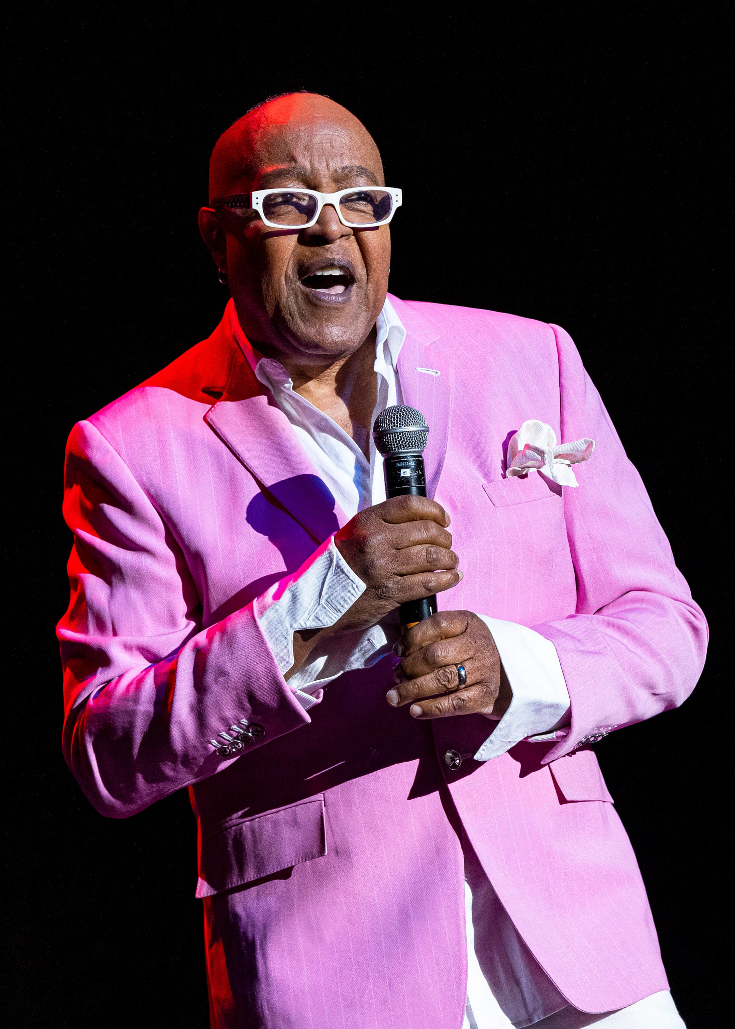 peabo bryson performing in a pink striped suit jacket