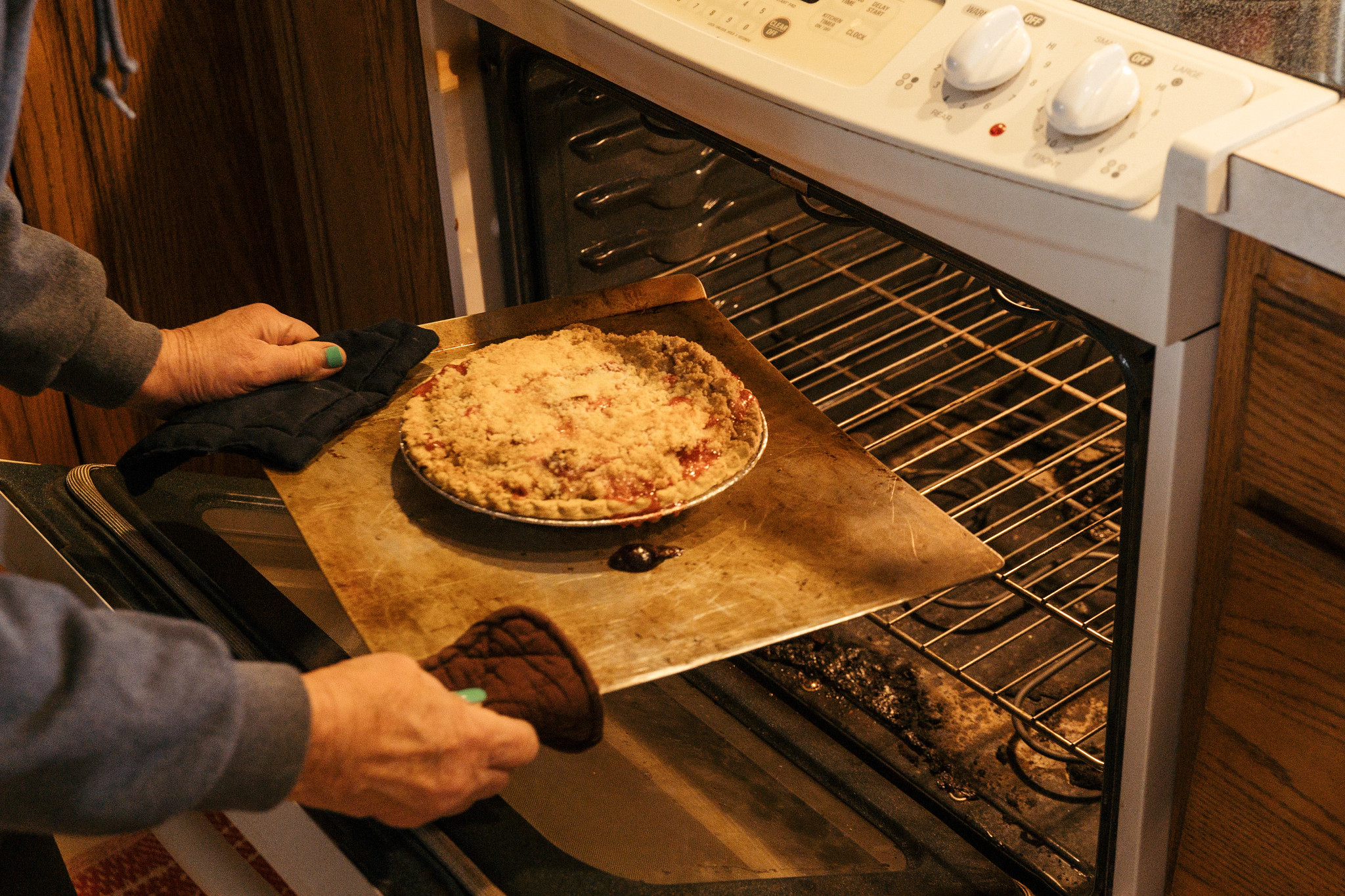 a photo shows Suanne Shoemaker taking a homemade pie out of the oven