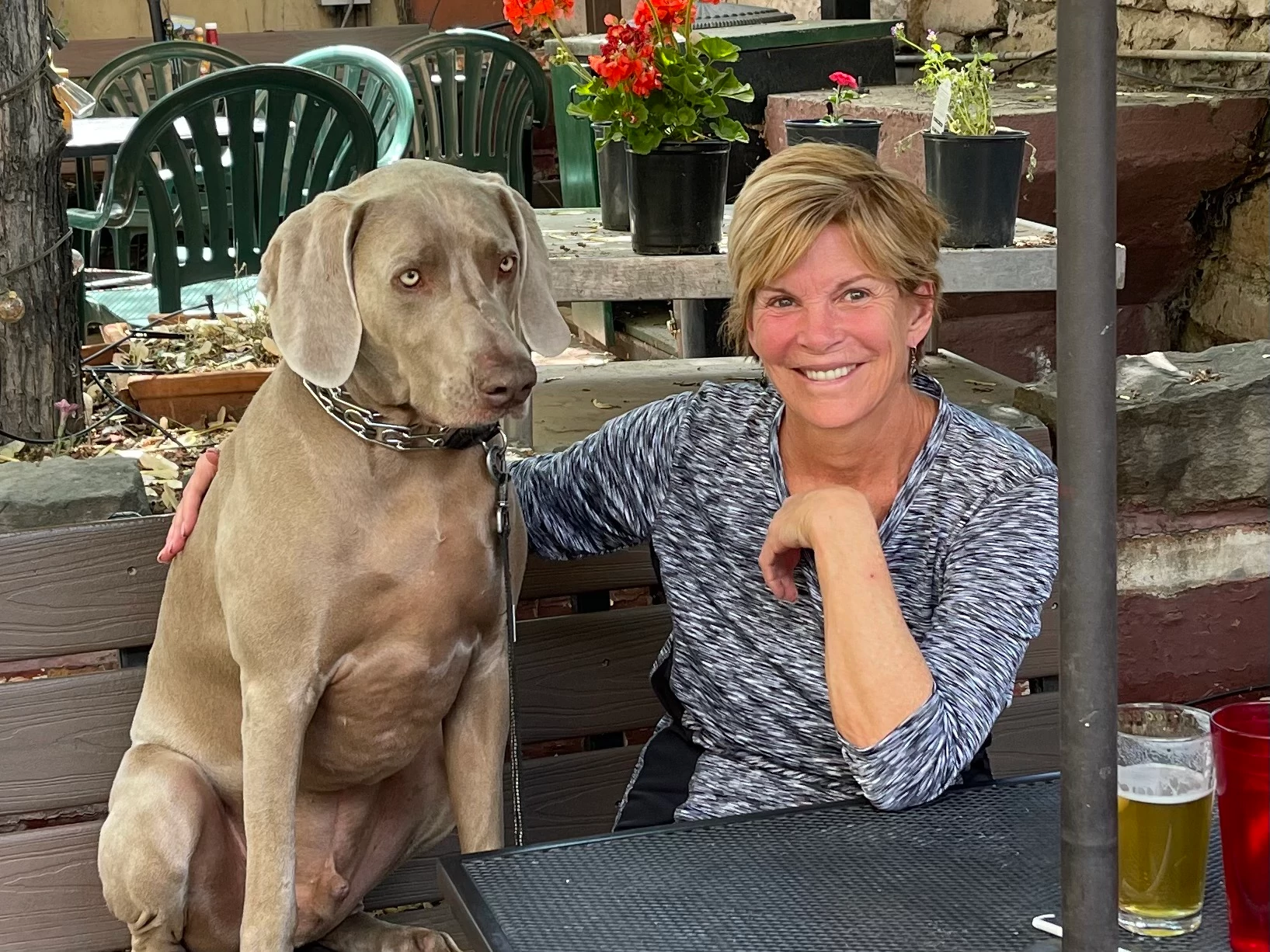a dog sitting next to a smiling woman