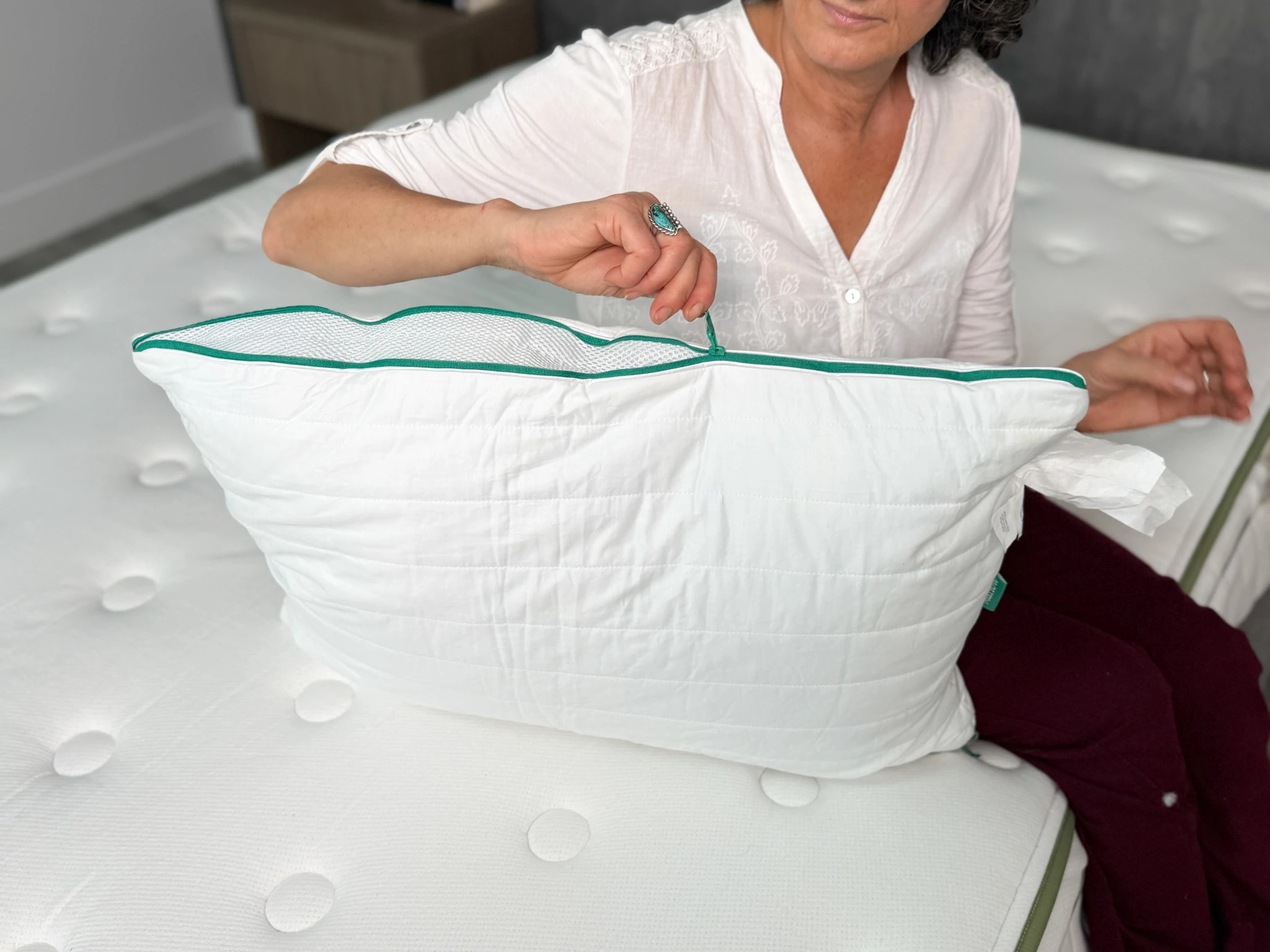 A woman zipping the size of the Brooklinen Marlow Pillow