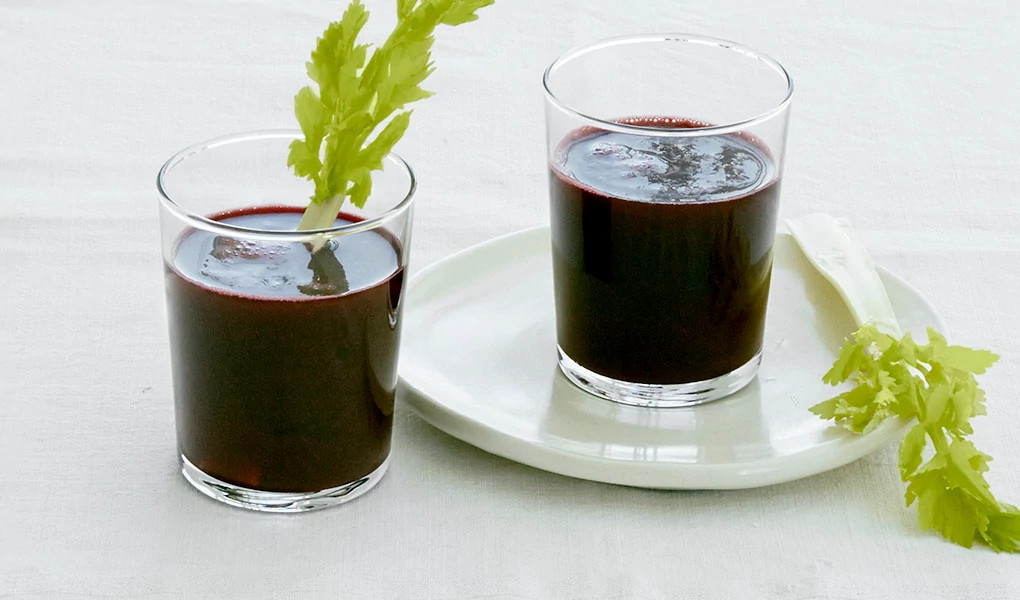 A close-up view of two glasses of beet root juice