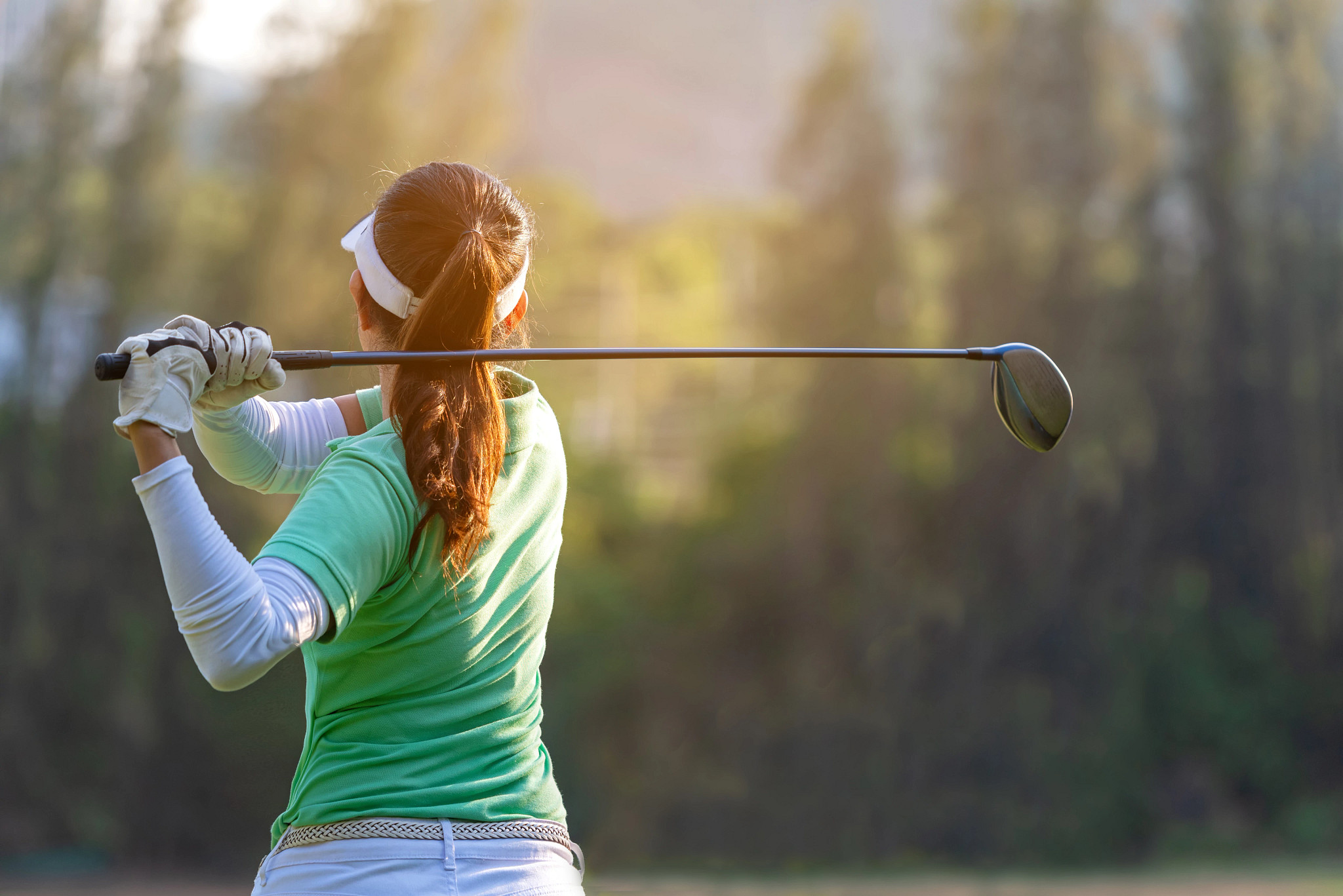 Adult golfer taking a swing on a golf course