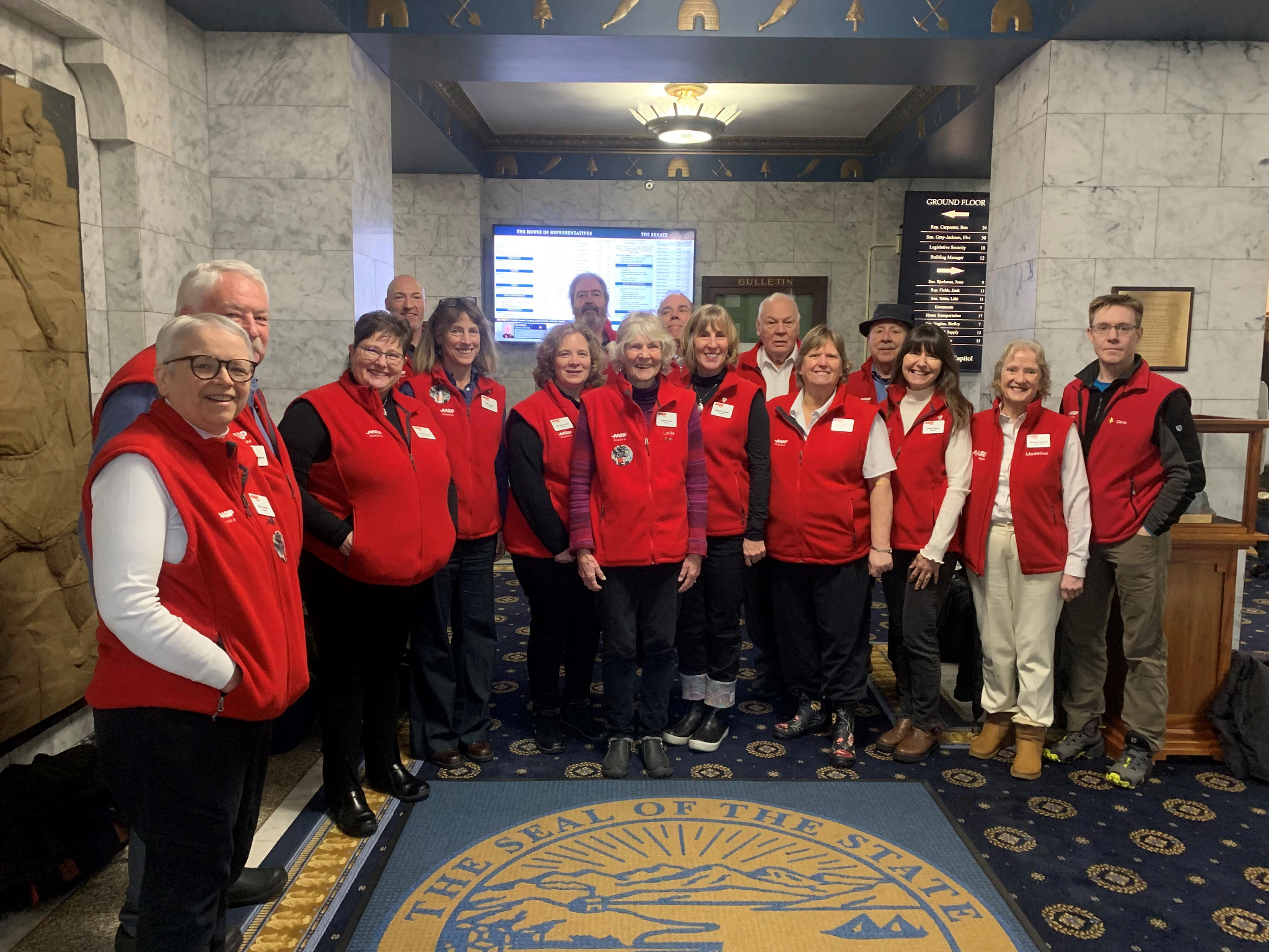 Multi-generational group of volunteers pose in the Alaska state capitol