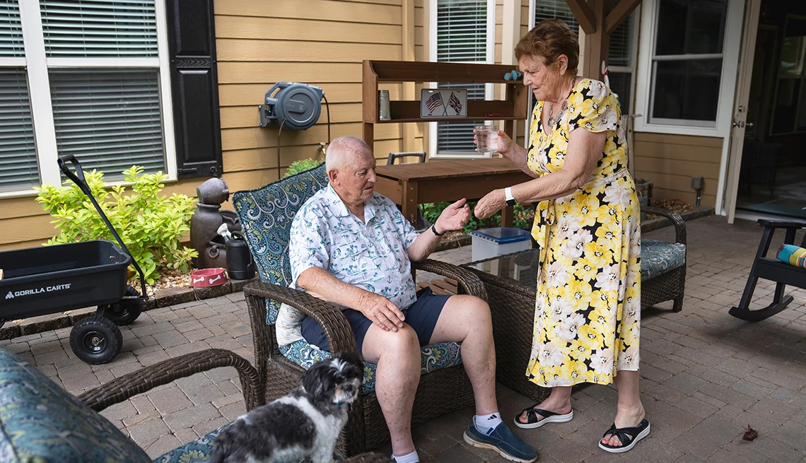jane cocking hands her husband, john, prescription pills