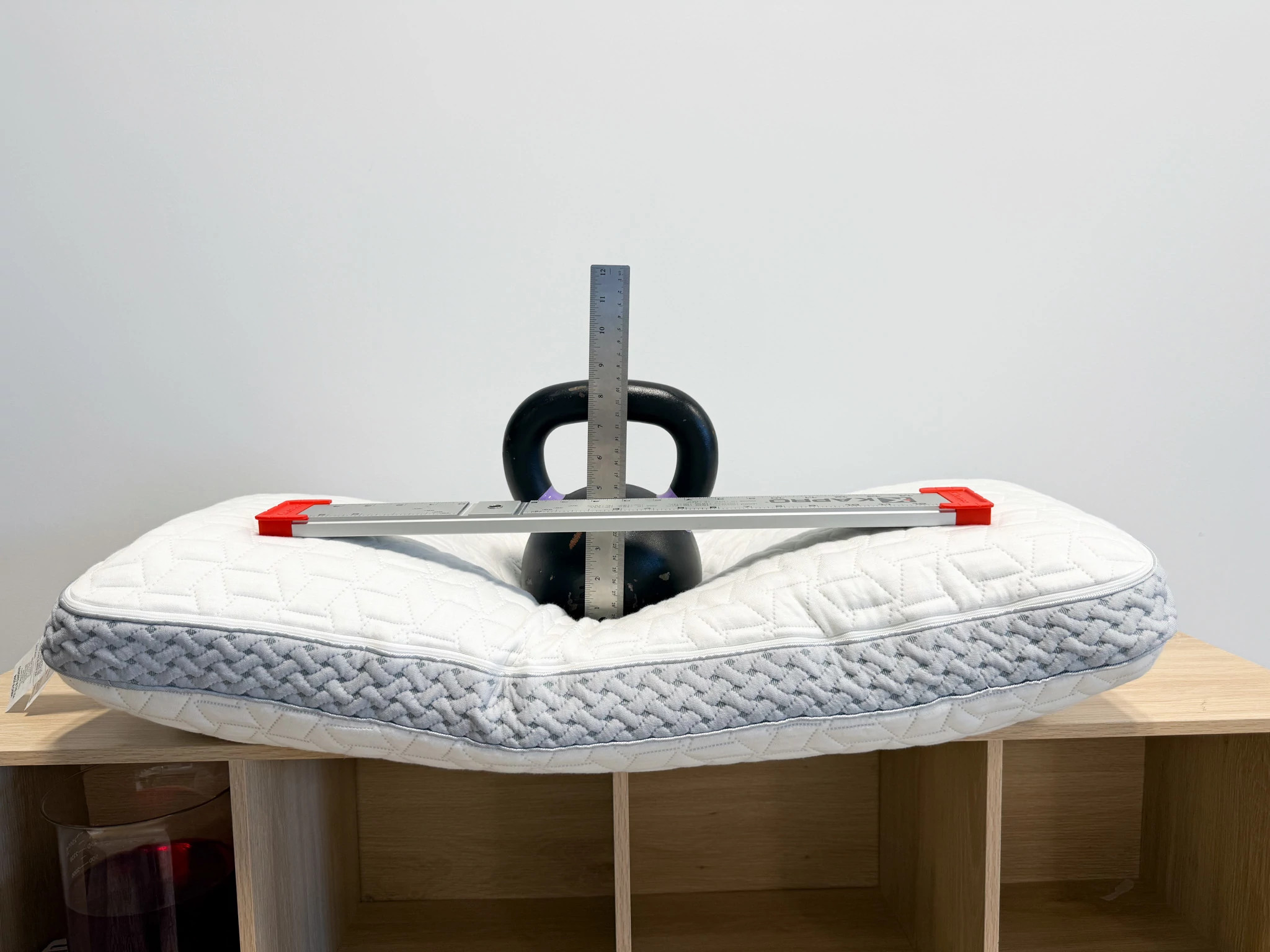 A kettlebell resting on the Luxome LAYR Customizable Pillow, as our team rated its sinkage