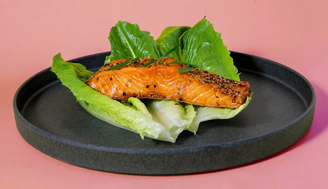 Smoked Salmon slice on black plate with yellow background