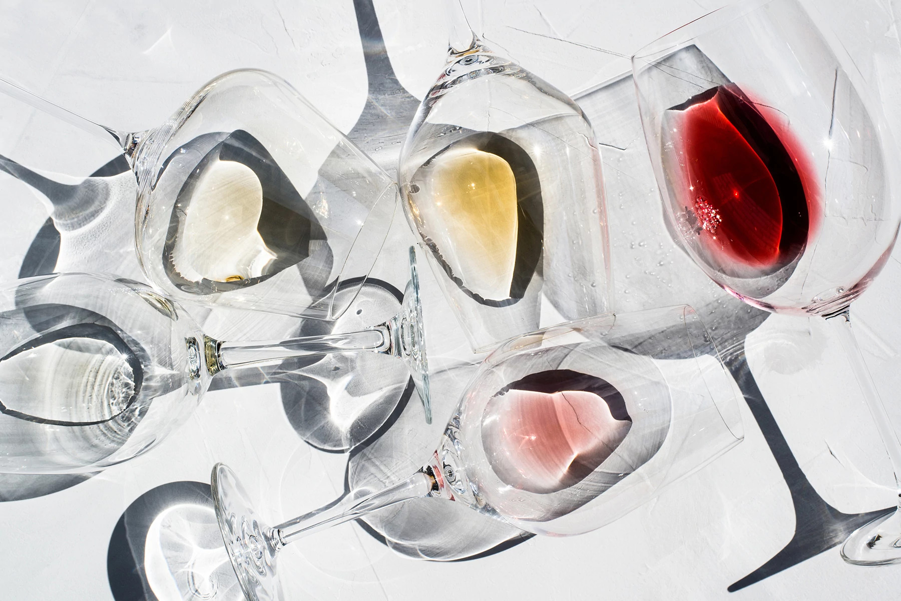 Wine Glasses on a white surface with With Different Types Of Wine inside