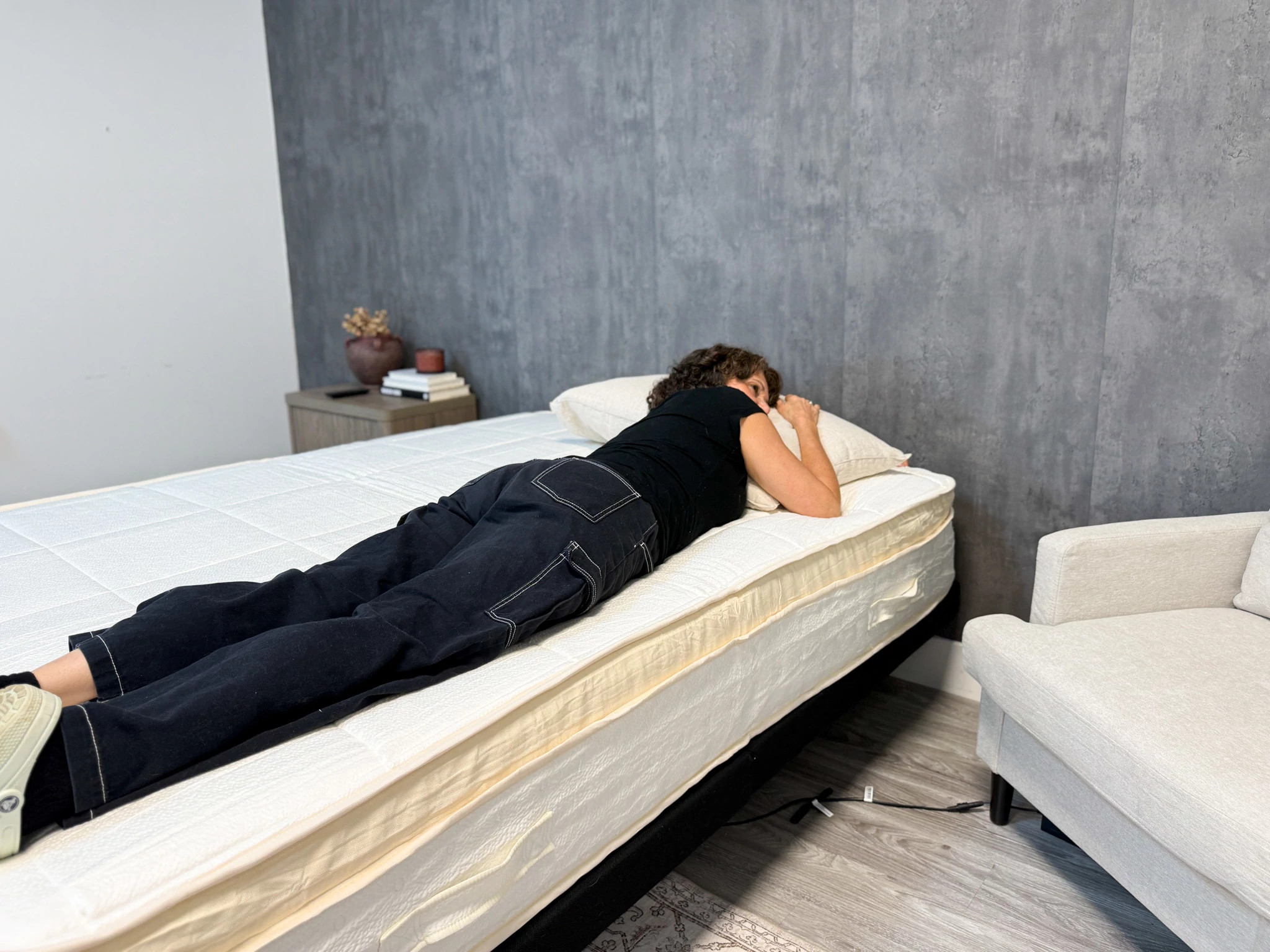 A woman stomach-sleeping on the Awara Premier Hybrid mattress
