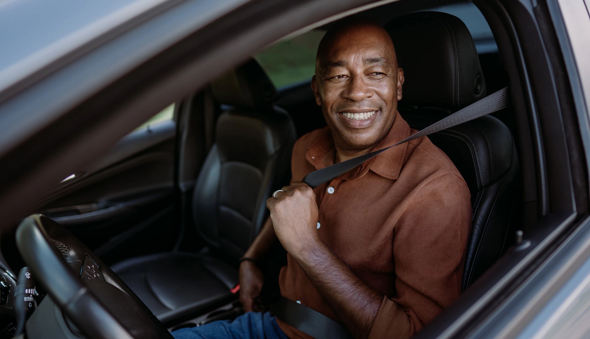 Man in car putting on his seatbelt Man in car putting on his seatbelt