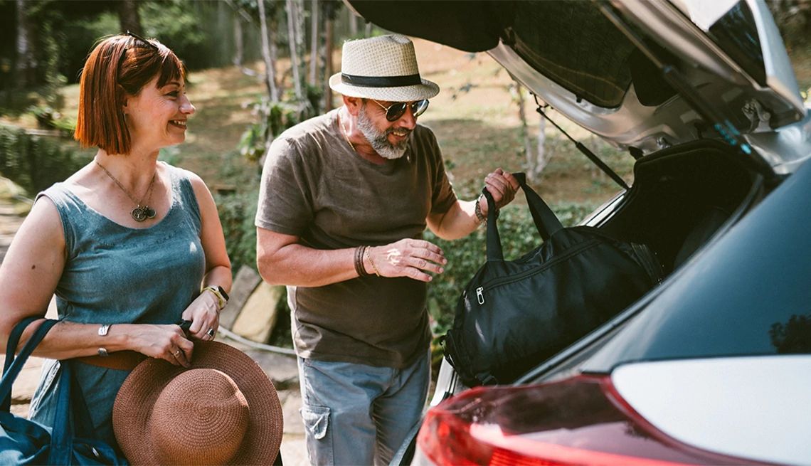 Couple packing bags into a car before the head out on a road trip