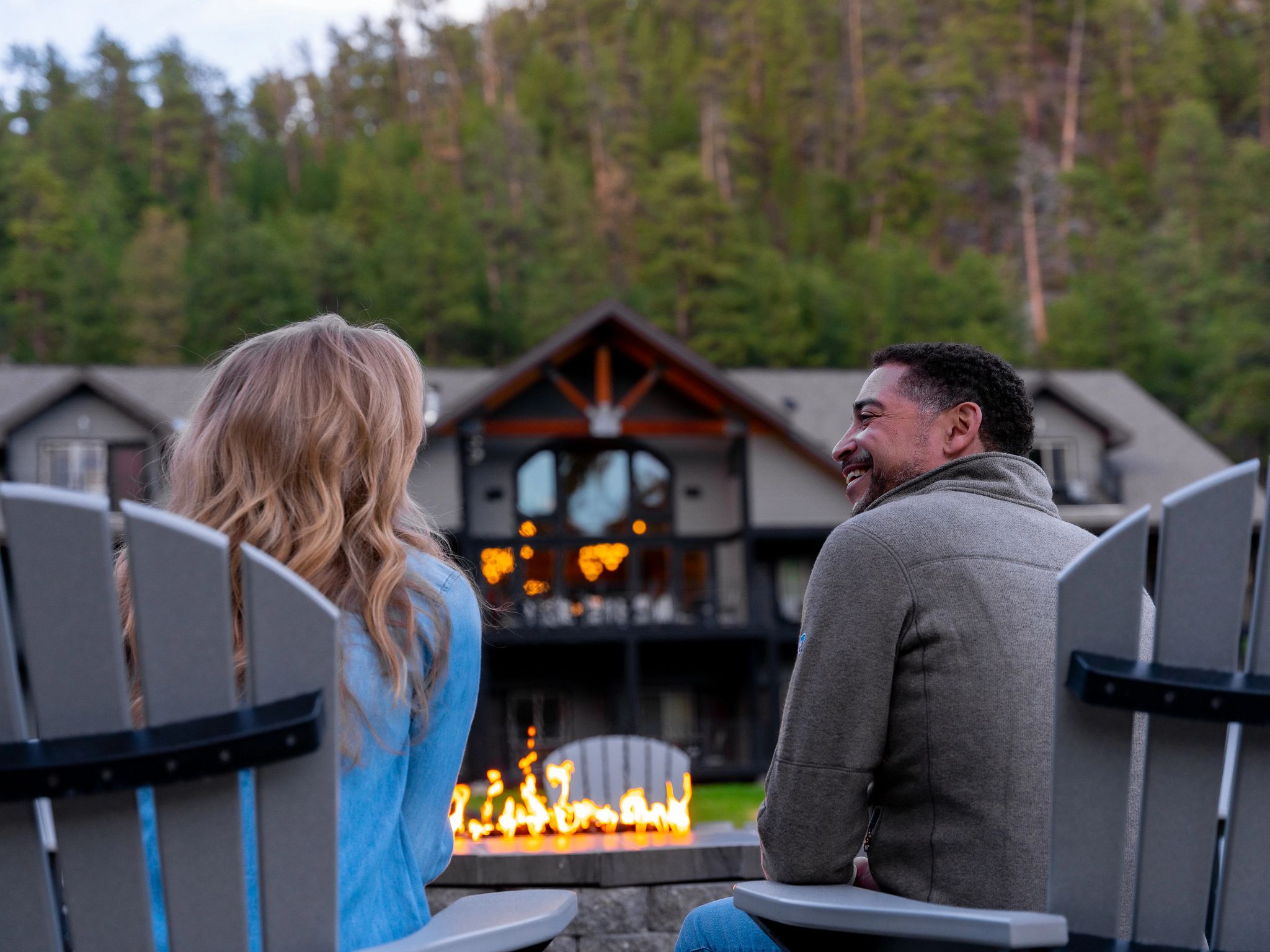 Couple laughing next to a bonfire
