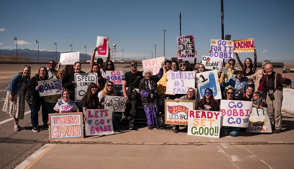 Wish of a Lifetime from AARP Family and friends cheering on a Wish of a Lifetime beneficiary holding signs at a race track