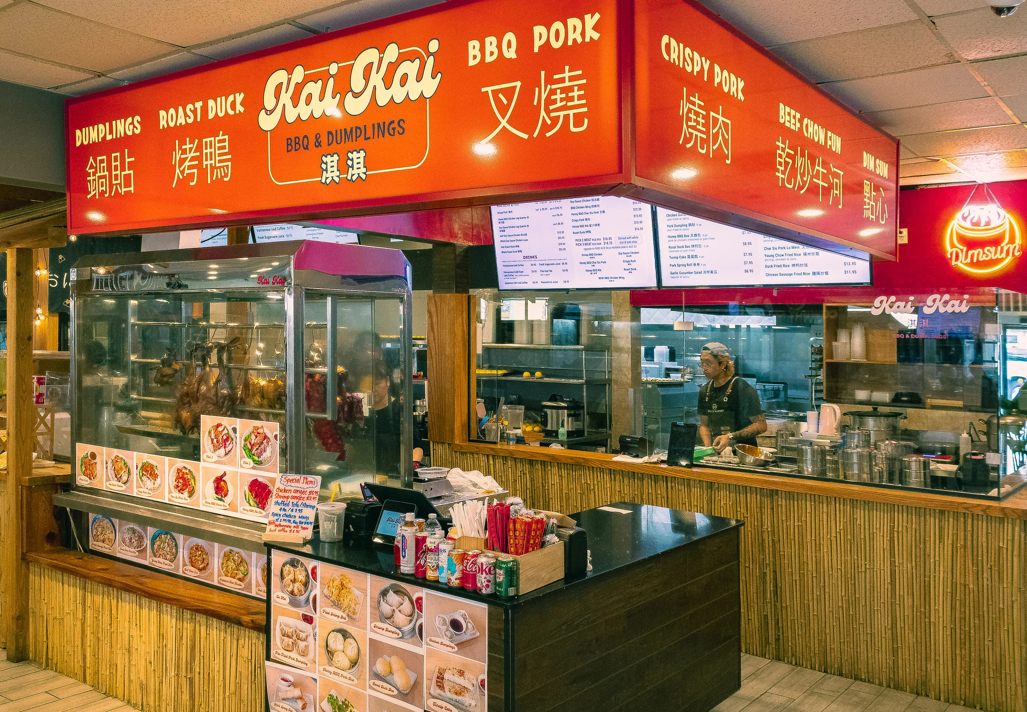 View of a dumpling stand with large red awning