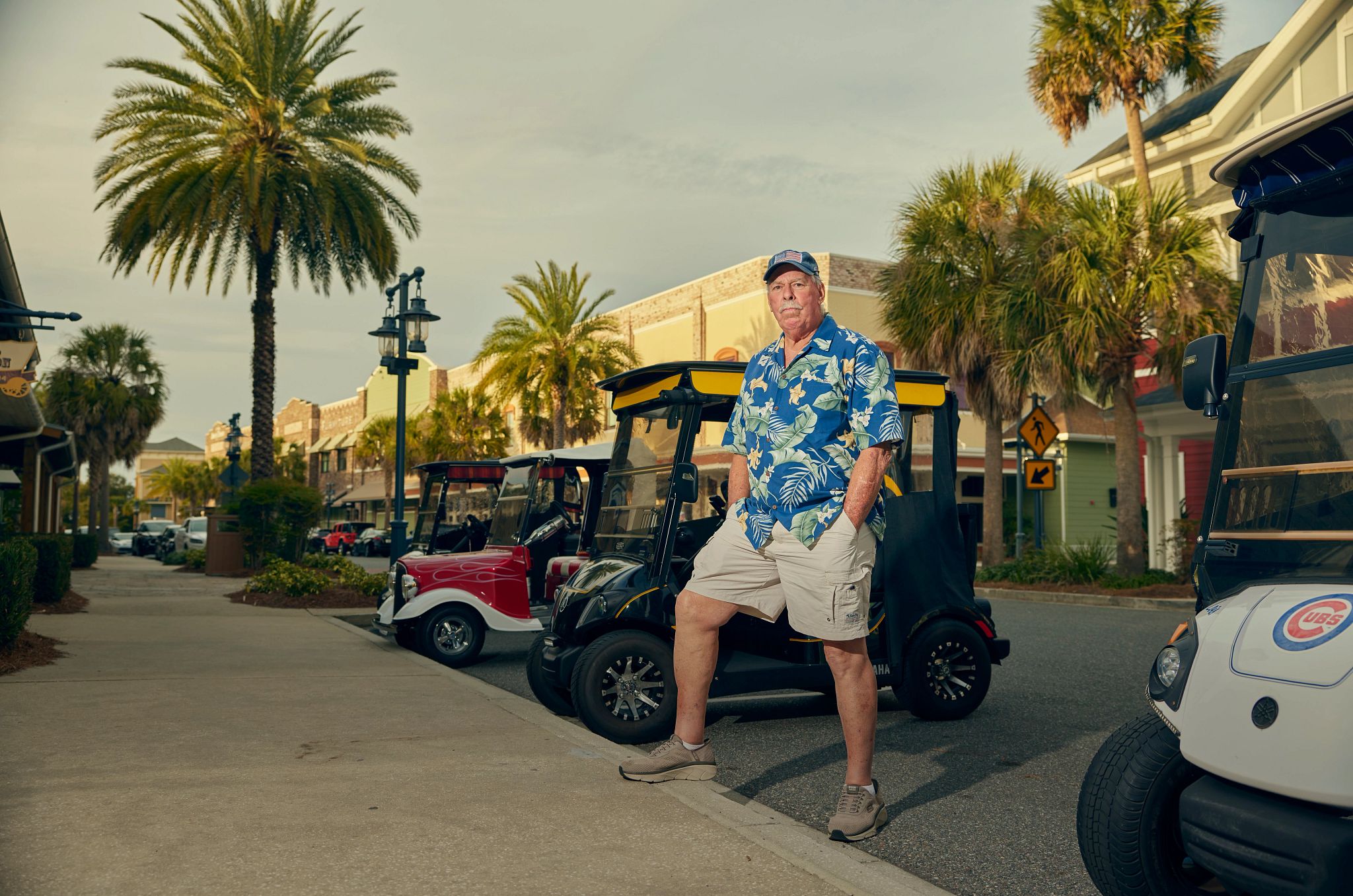 Scams Target Retirement Communities a man in a floral print shirt stands in front of golf carts
