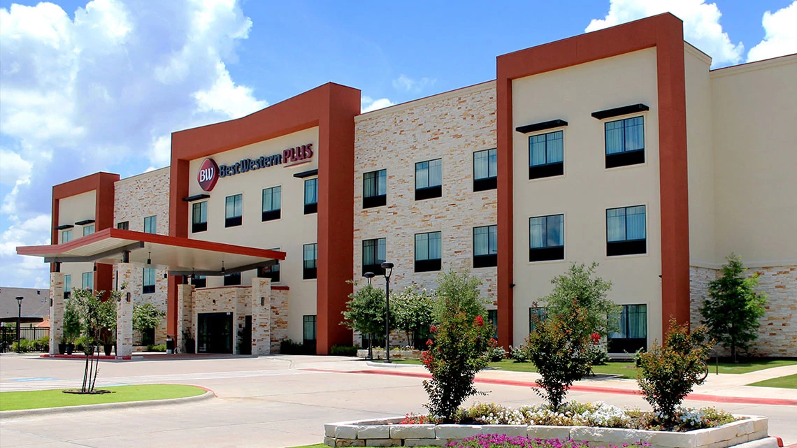 Best Western Plus® Best Western hotel front of hotel with covered entrance, parking lot, sunny day