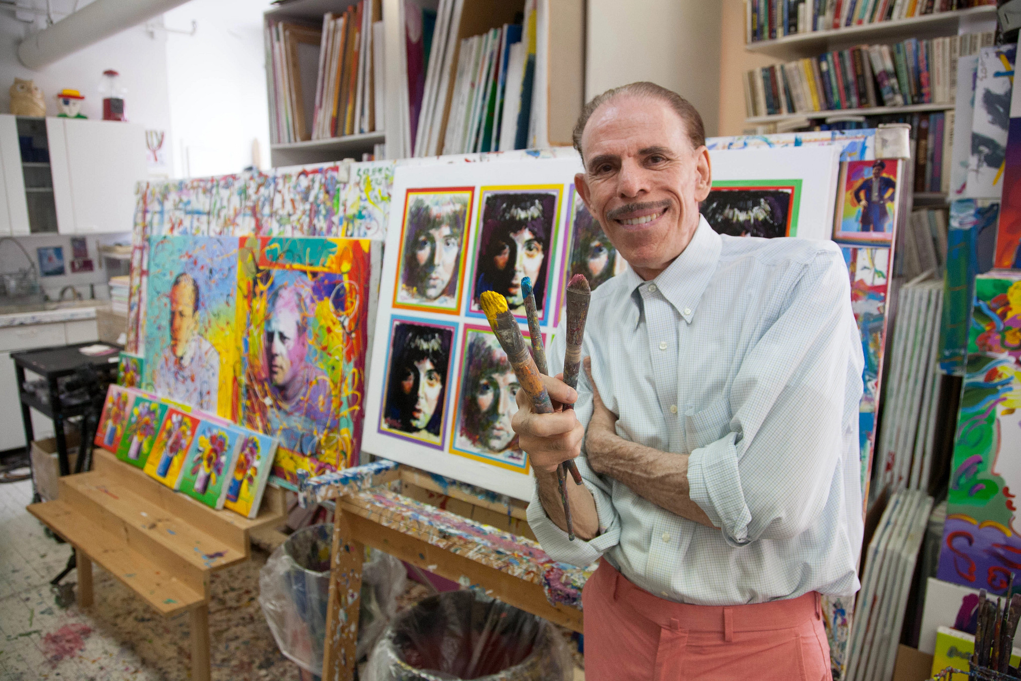peter max in his studio with paint brushes and works of art