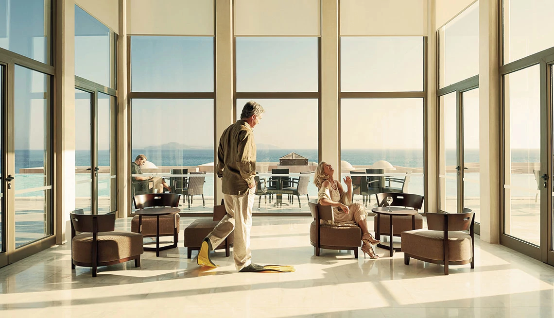 man walking with flippers and woman sitting in hotel lobby