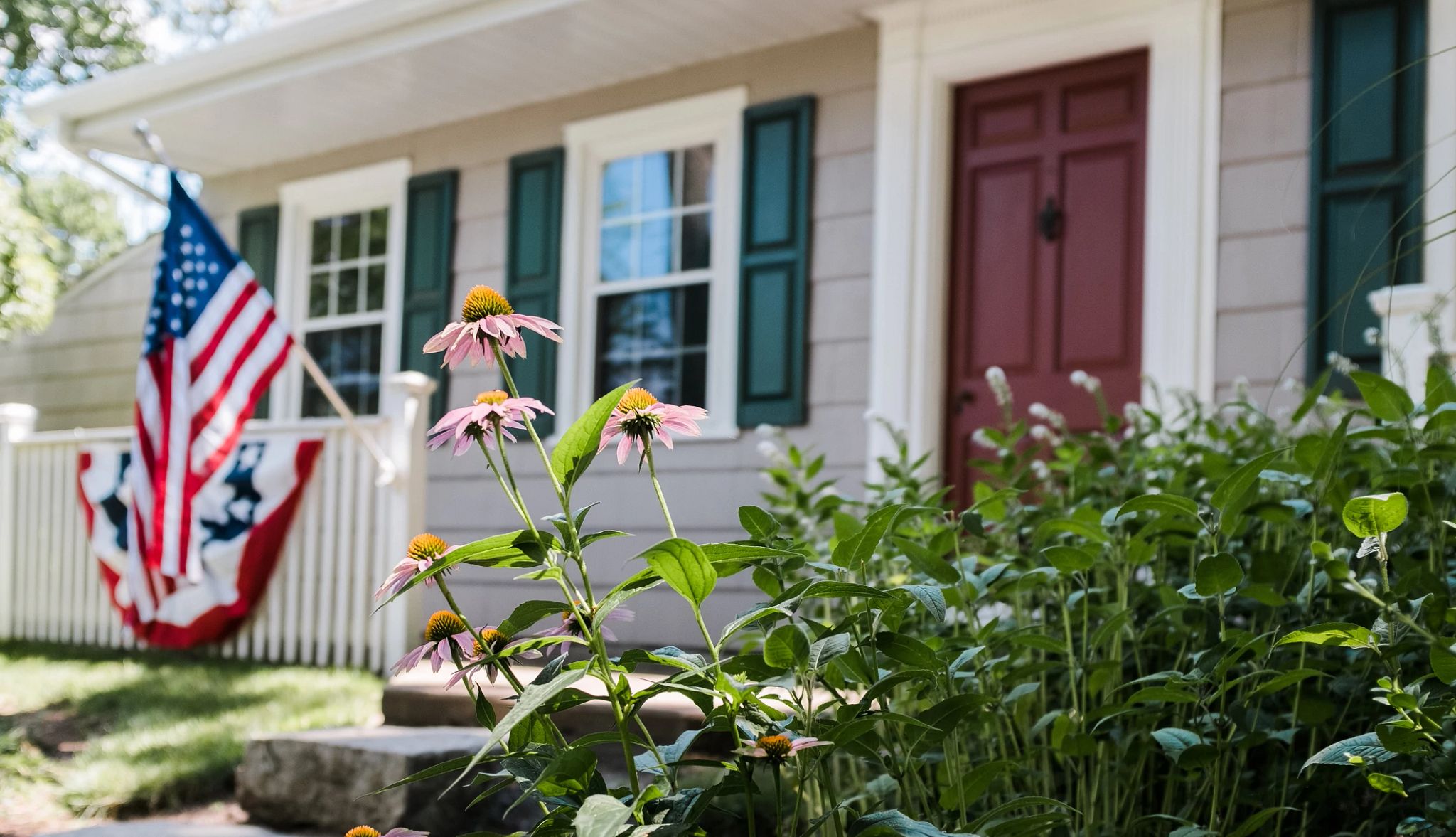 Front of house with flowers and flag. Front of house with flowers and flag.