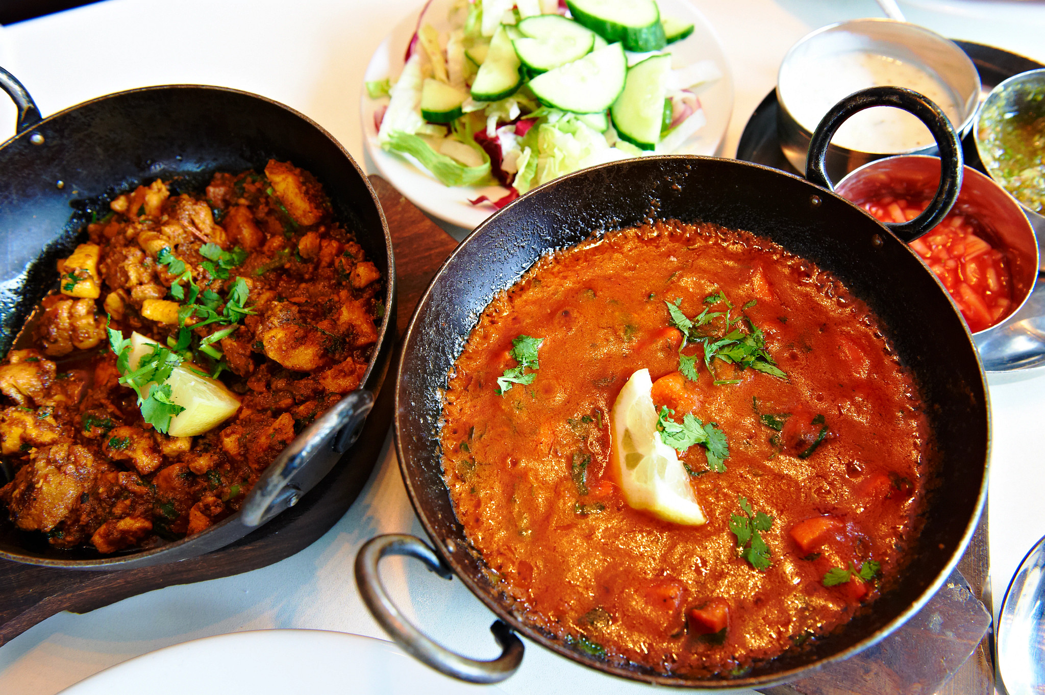 A collection of Indian dishes, including a curry dish at Akbar cafe and restaurant