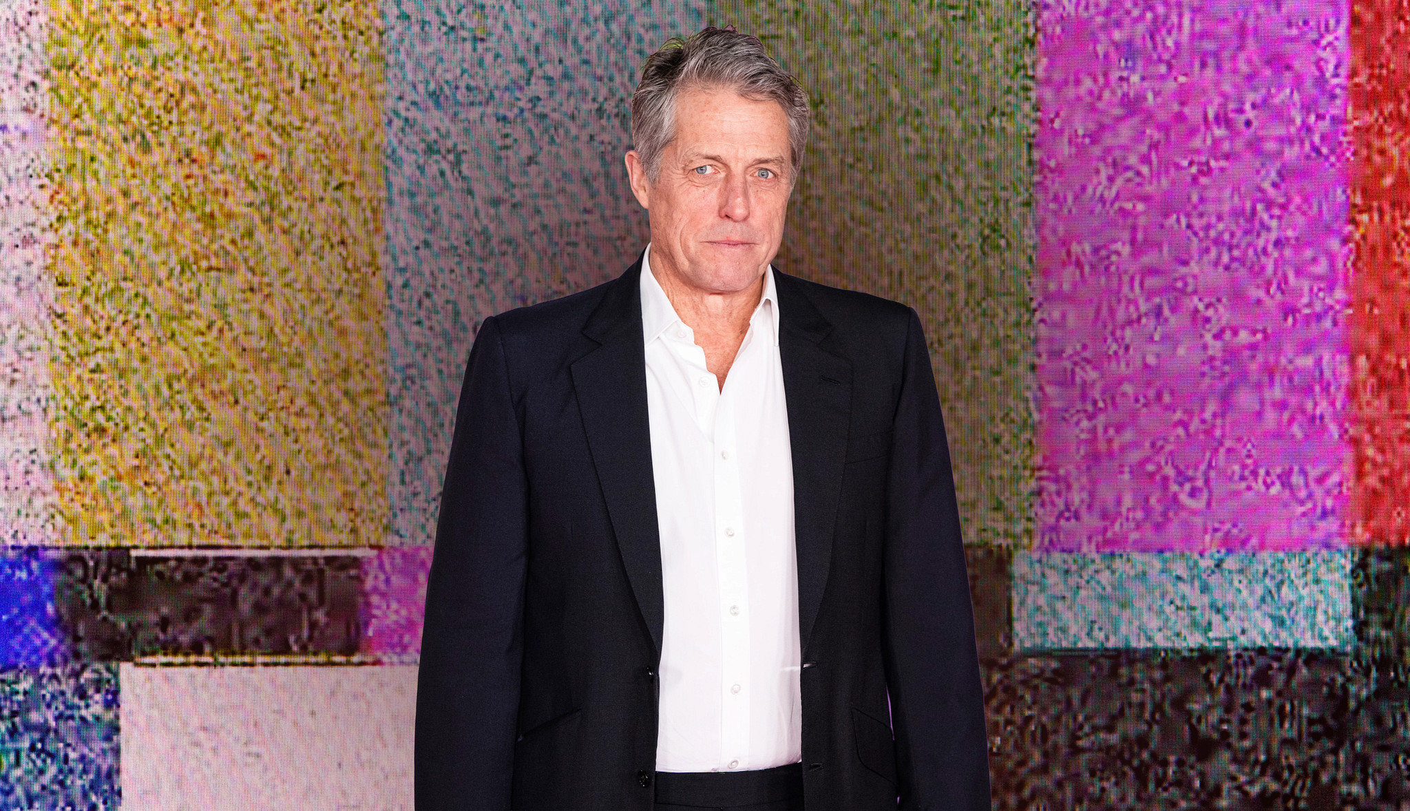 a collage with hugh grant in front of an image of a screen with static and no signal