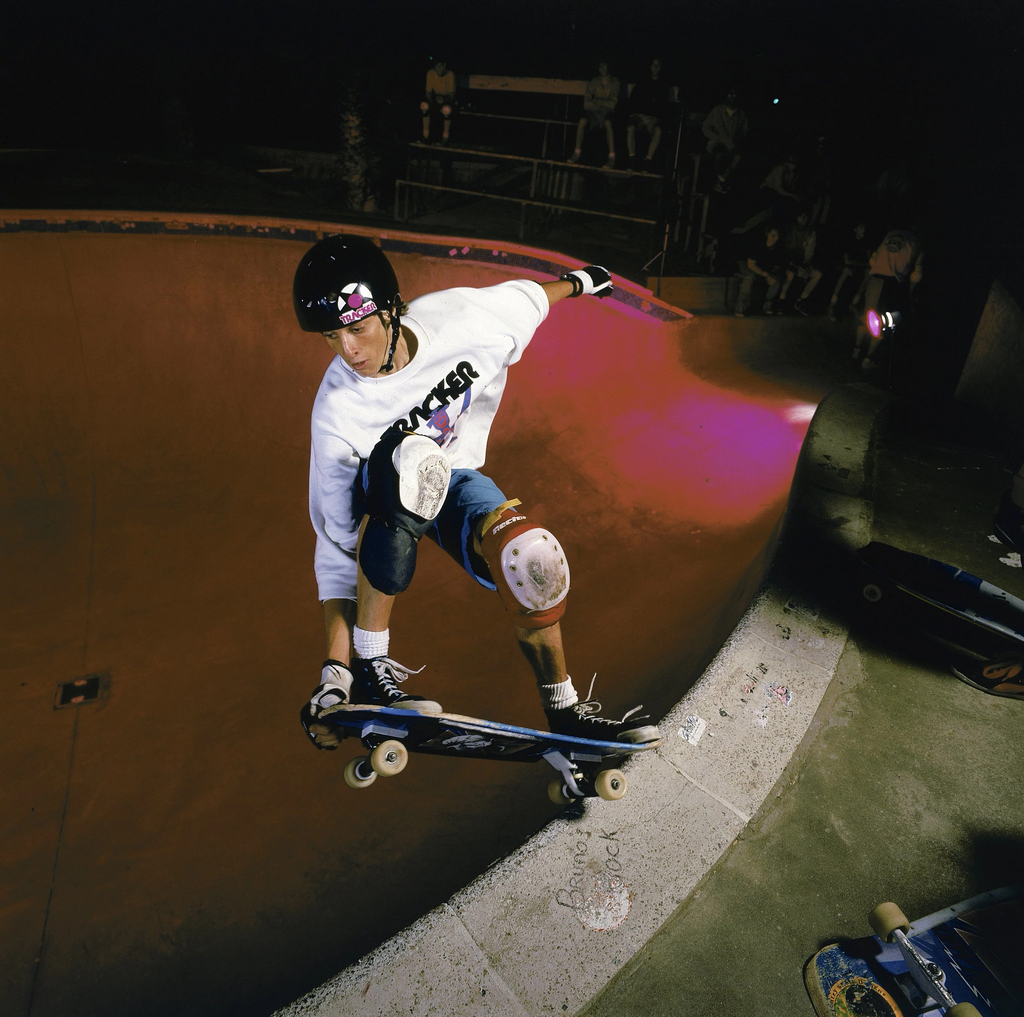 a photo shows Tony Hawk carving a up a swimming pool on his skateboard