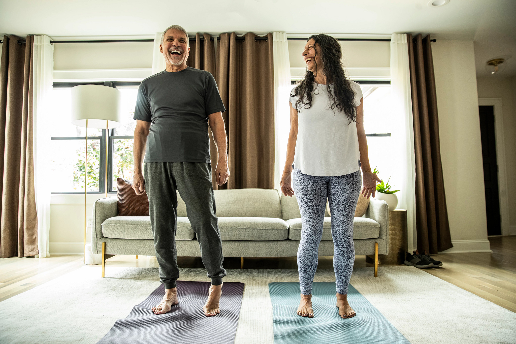 Senior couple doing yoga inside home