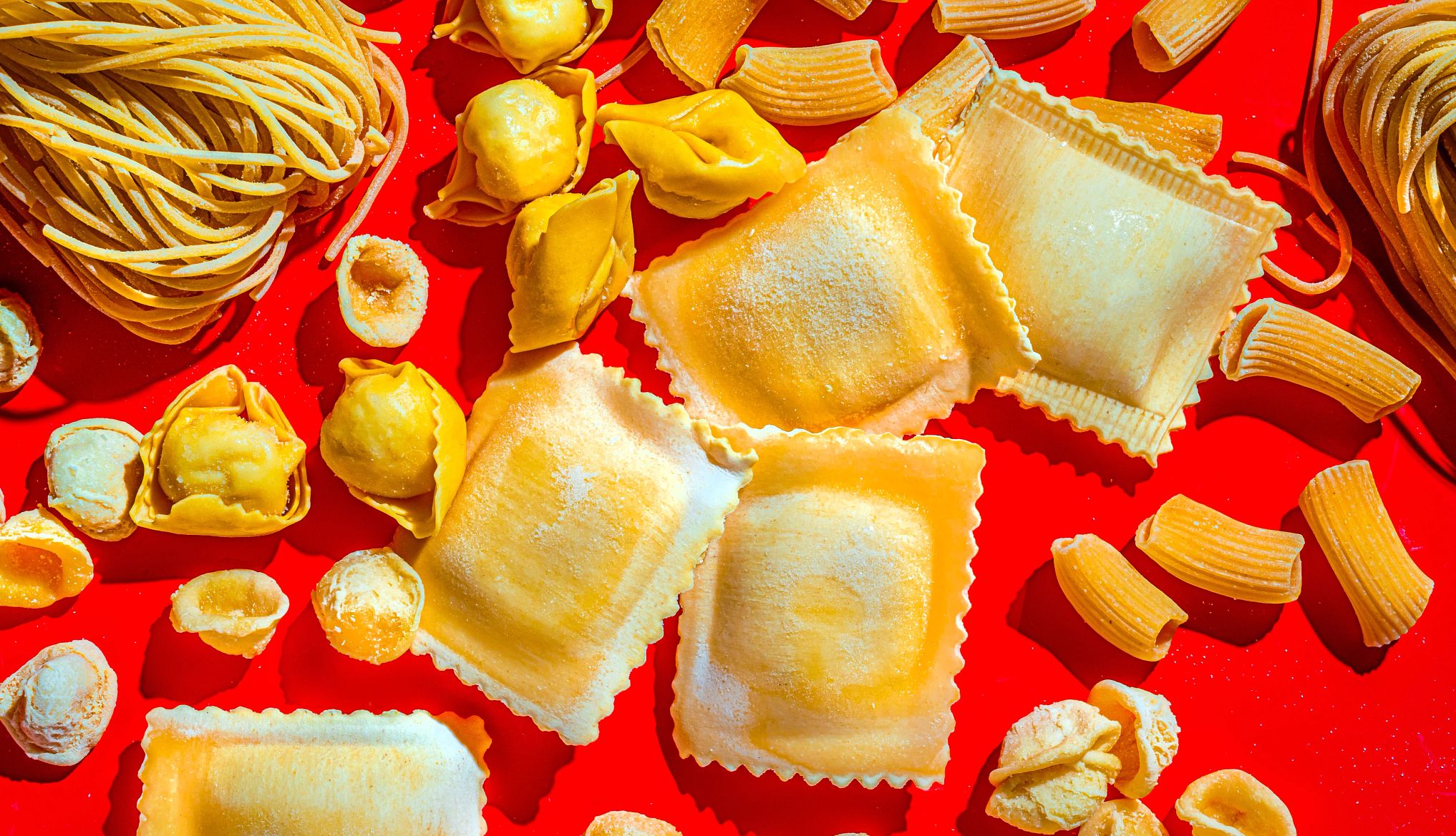 assorted pasta on a red background