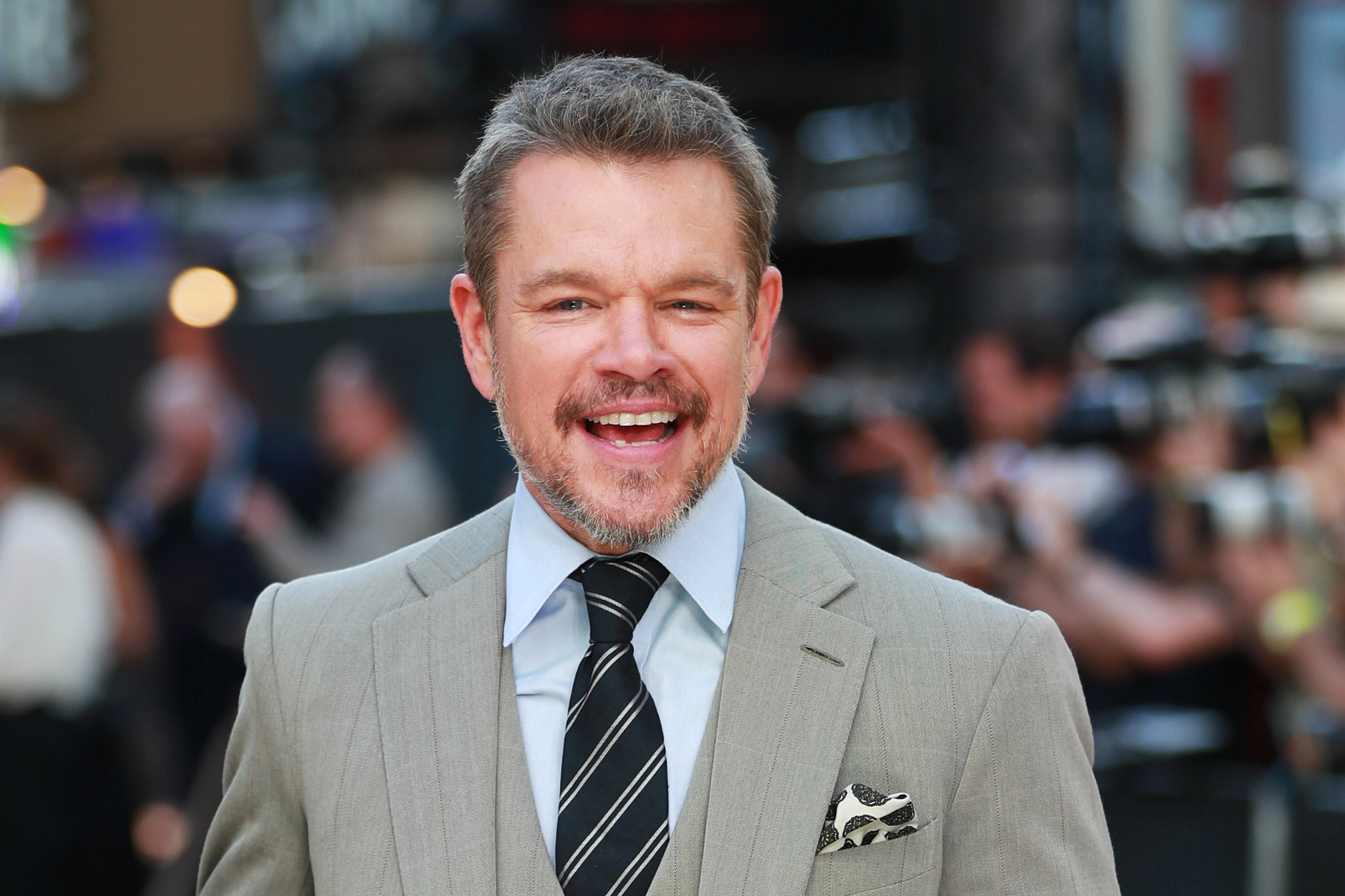 matt damon, smiling in a jacket and tie