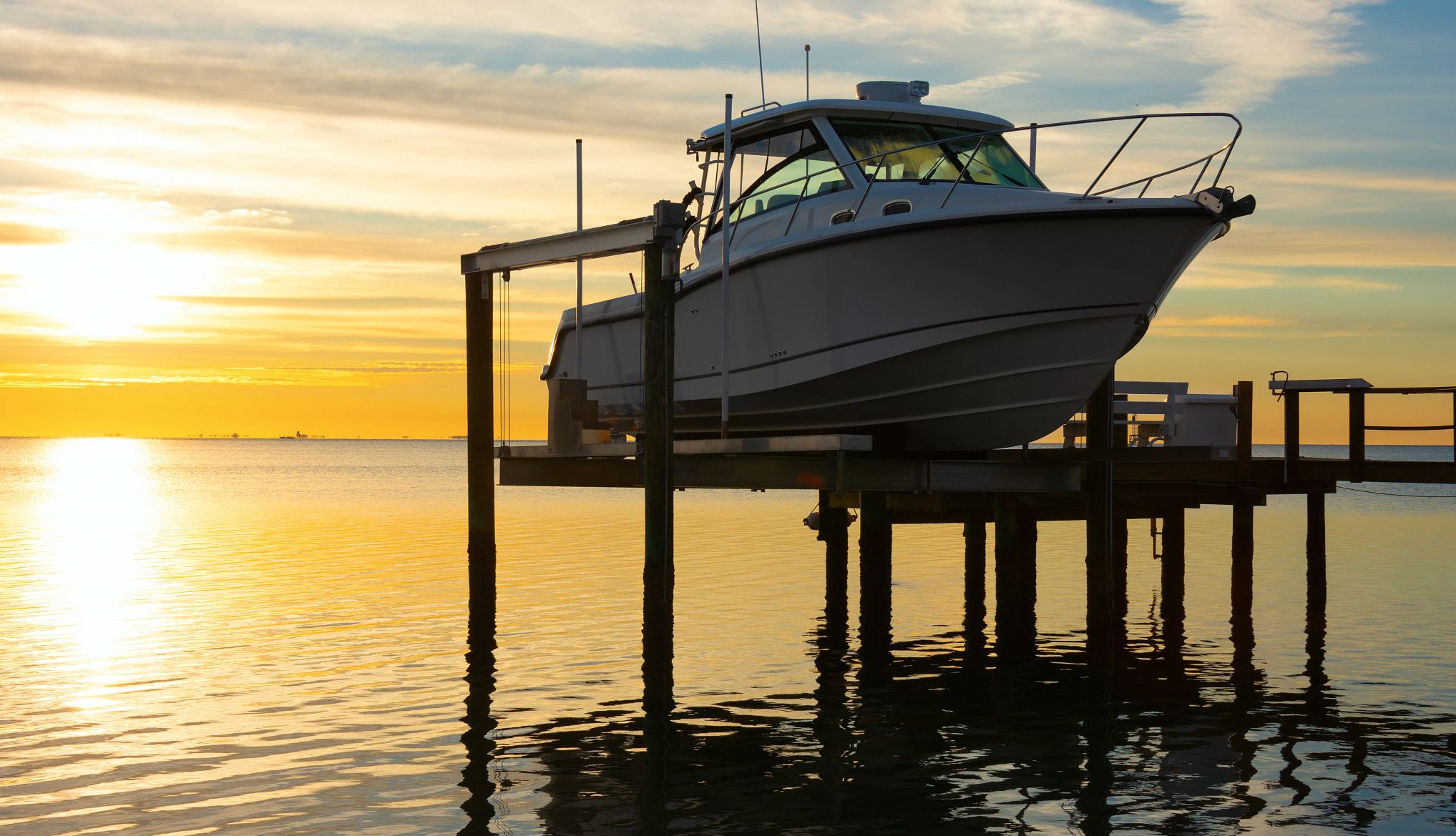 Compras de las que se arrepienten los jubilados Un barco en un muelle con un sol naciente al fondo.