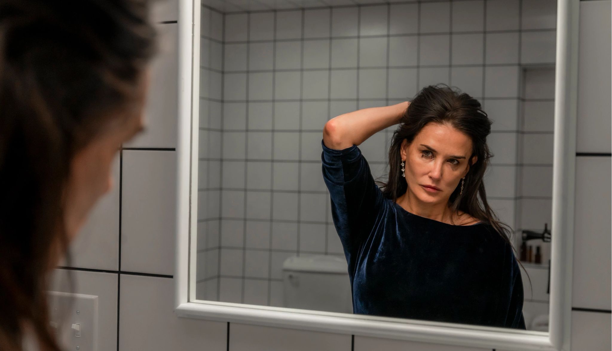 the substance demi moore looks in the mirror during in a scene from substance movie