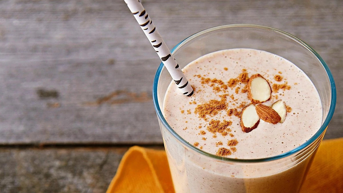 A close-up view of almond butter and banana protein smoothie in a glass