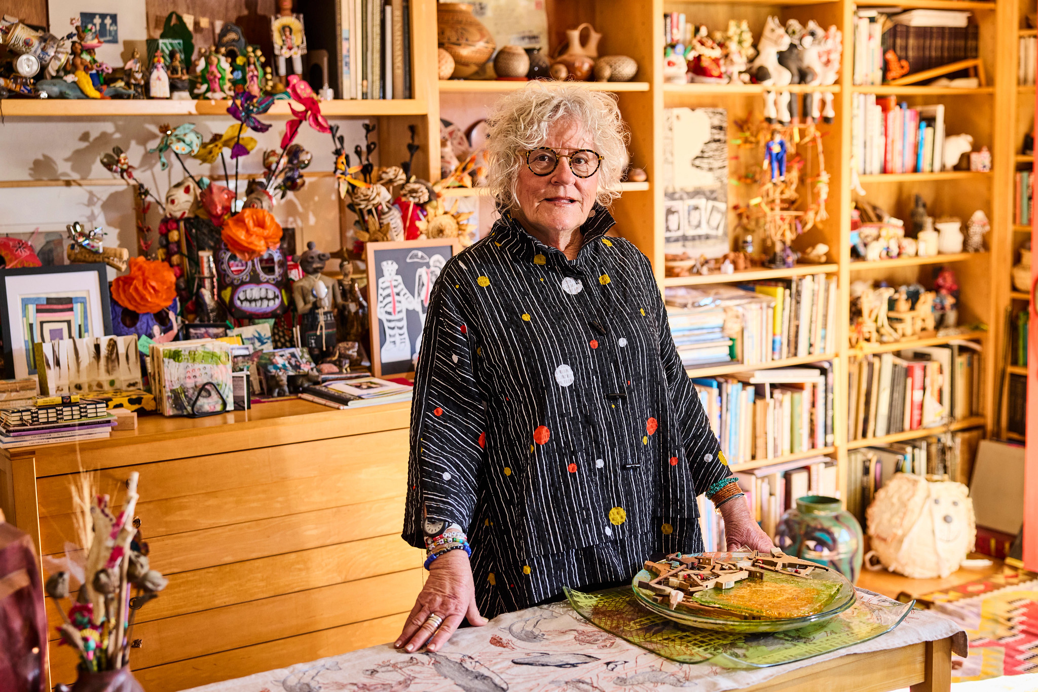 jane gregorius stands in her home studio, surrounded by art