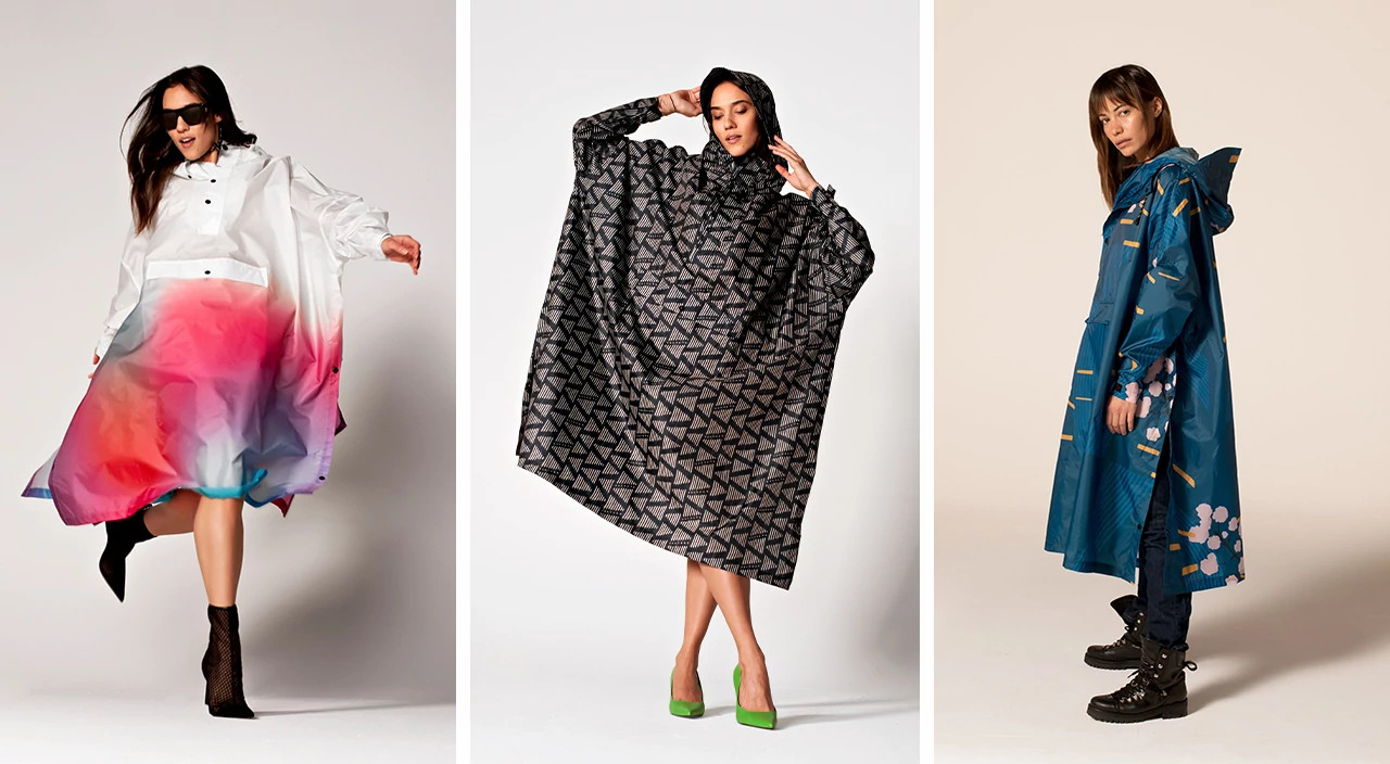 Three people modeling colorful rain ponchos in pink ombre, black geometric, and teal floral prints