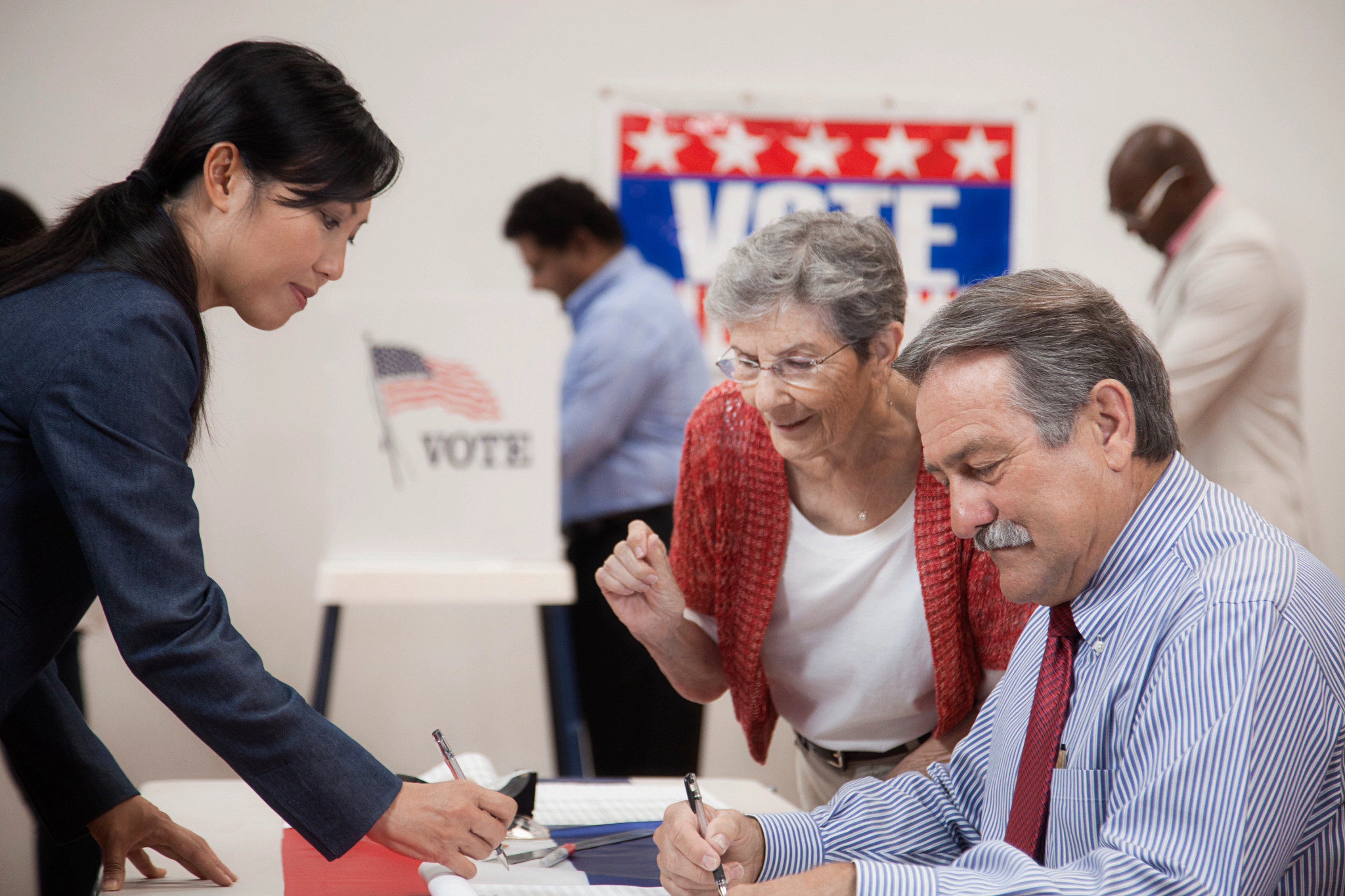 Woman arriving at registration desk in polling place
