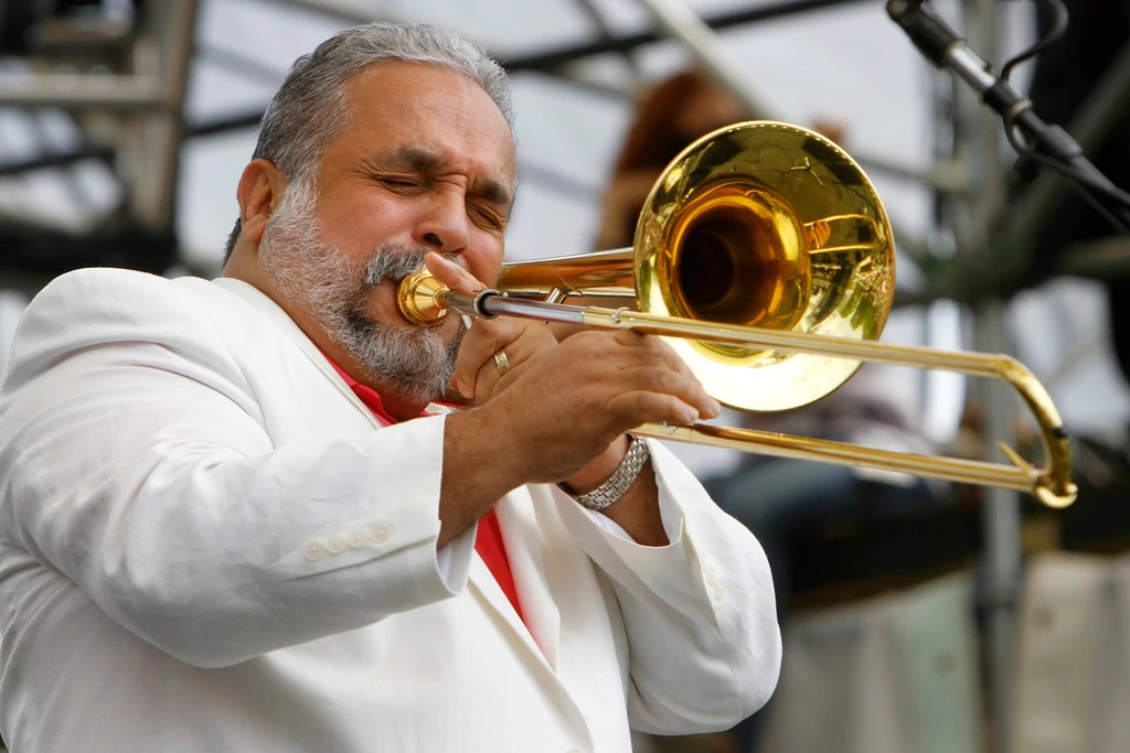 willie colon playing a trombone on stage