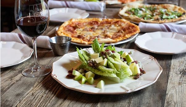 Siren Song Vineyard in Chelan, WA Several plates of food and glass of red wine on table