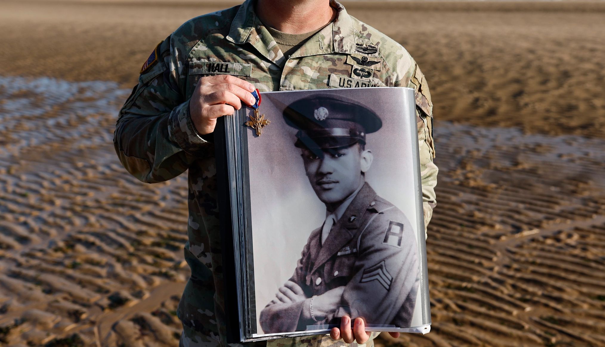 How AARP Helps Veterans a person in a u s army uniform holds a military medal and a black and white image of another soldier