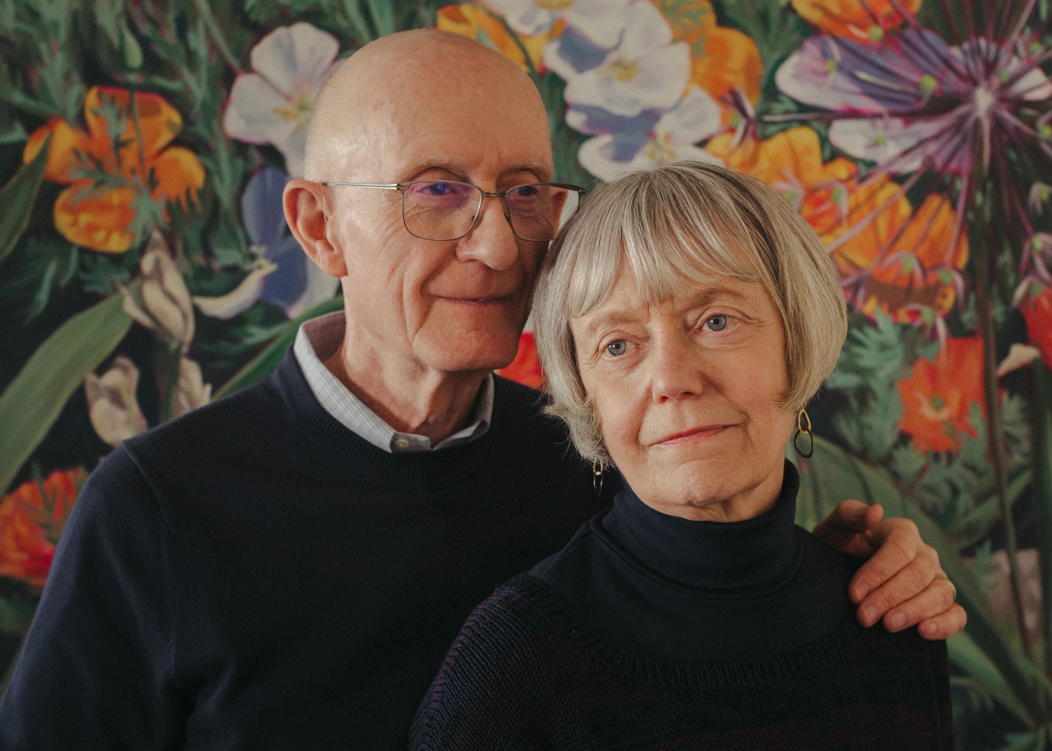 Rebecca Chopp and Fred Thibodeau Rebecca Chopp and her husband, Fred Thibodeau, stand in front of a bright floral wallpaper.
