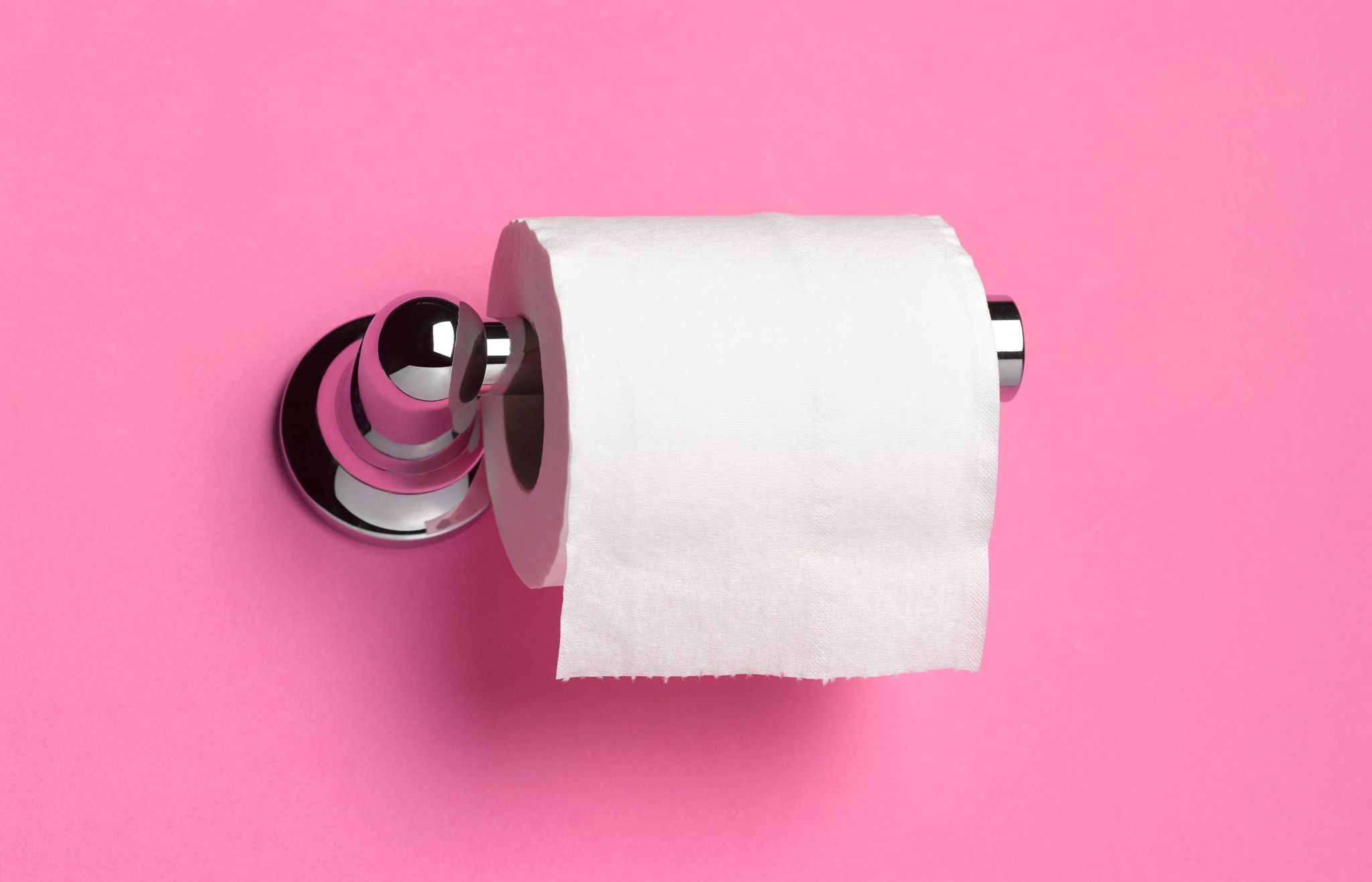 toilet paper on a holder and pink background