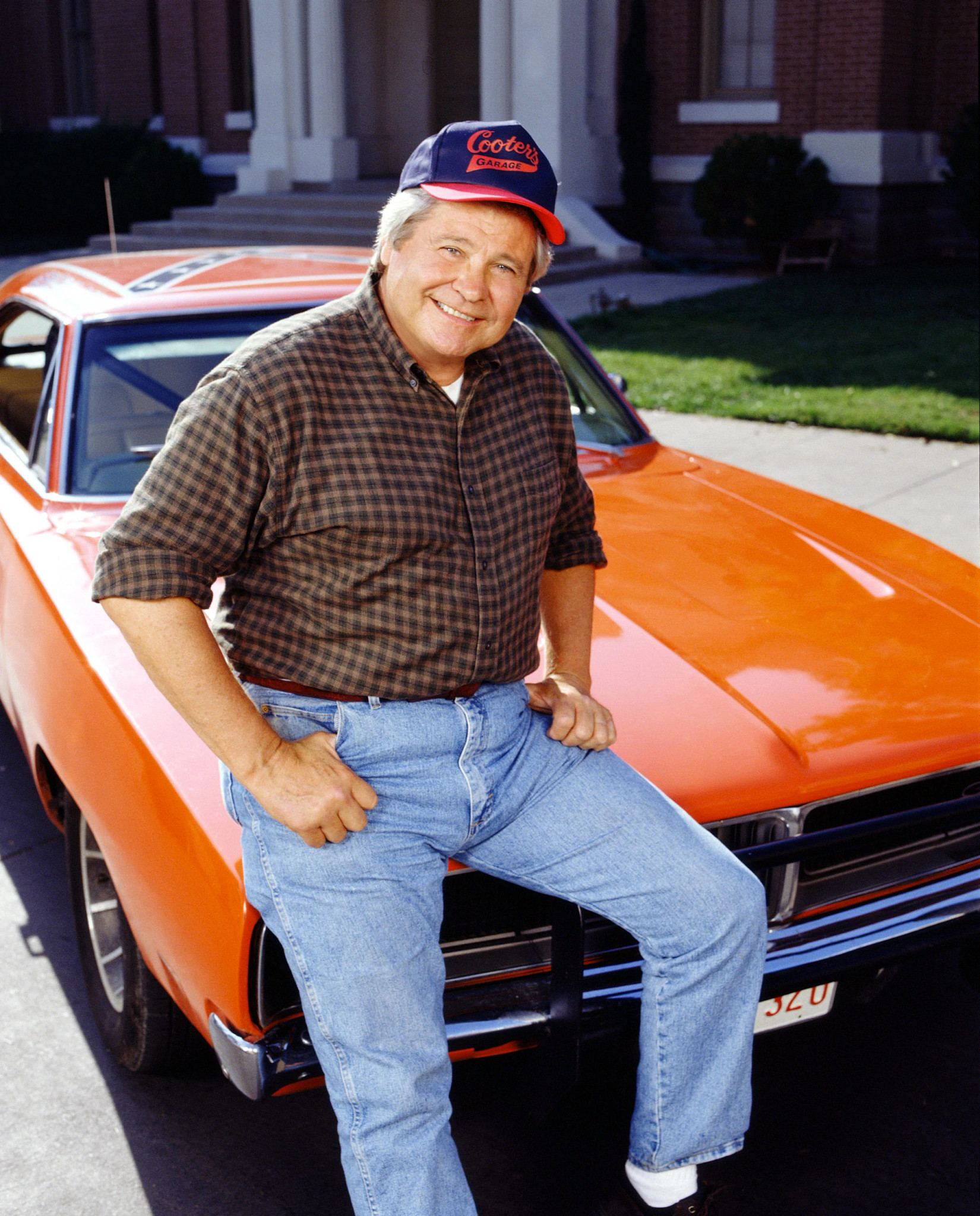 ben jones in his cooter ballcap next to the car the general lee